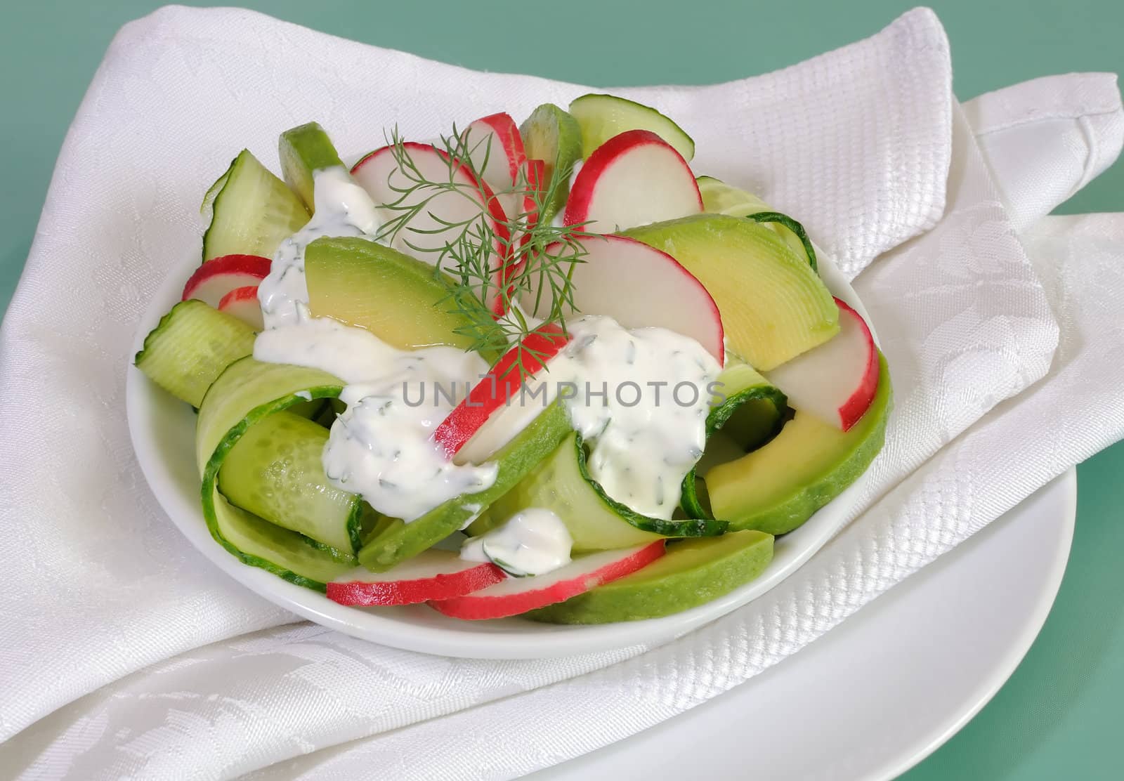 Cucumber salad with radish and avocado cream sauce and dill