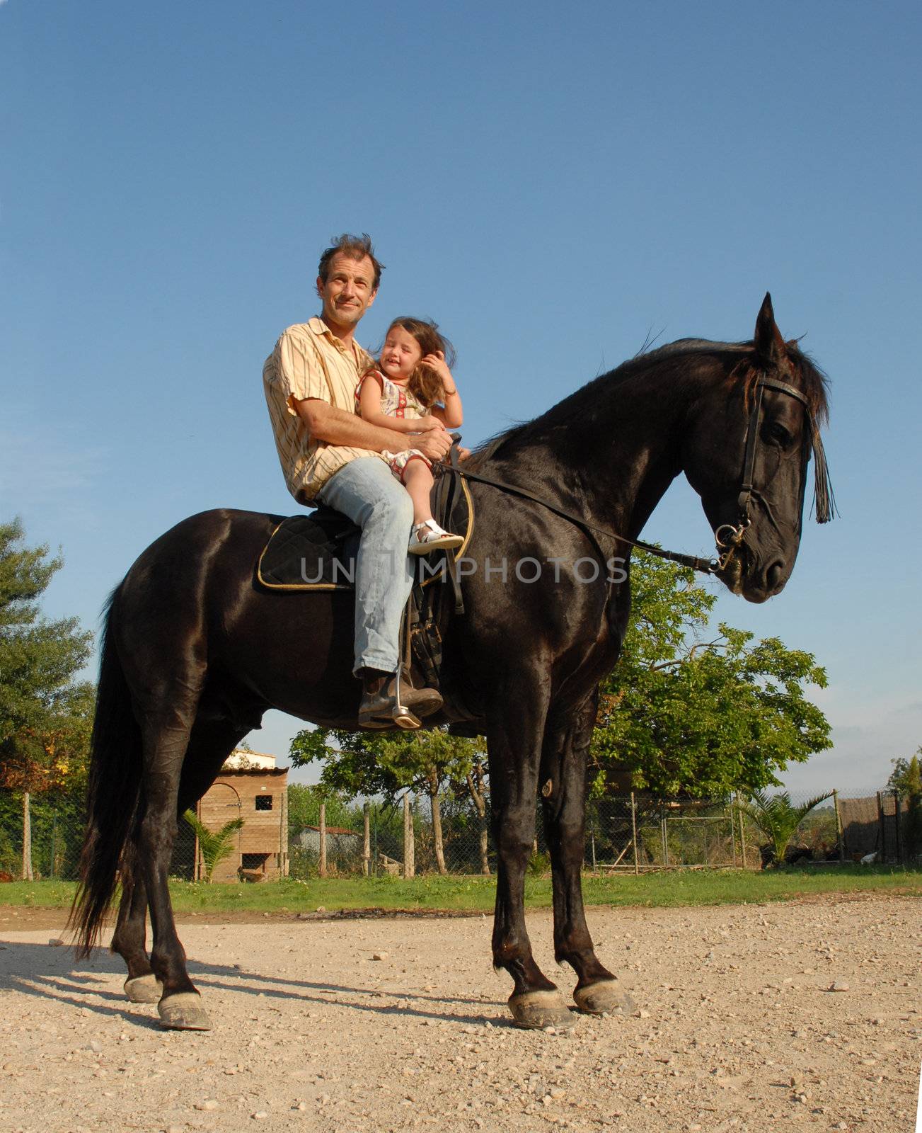 father and his daughter on a black horse