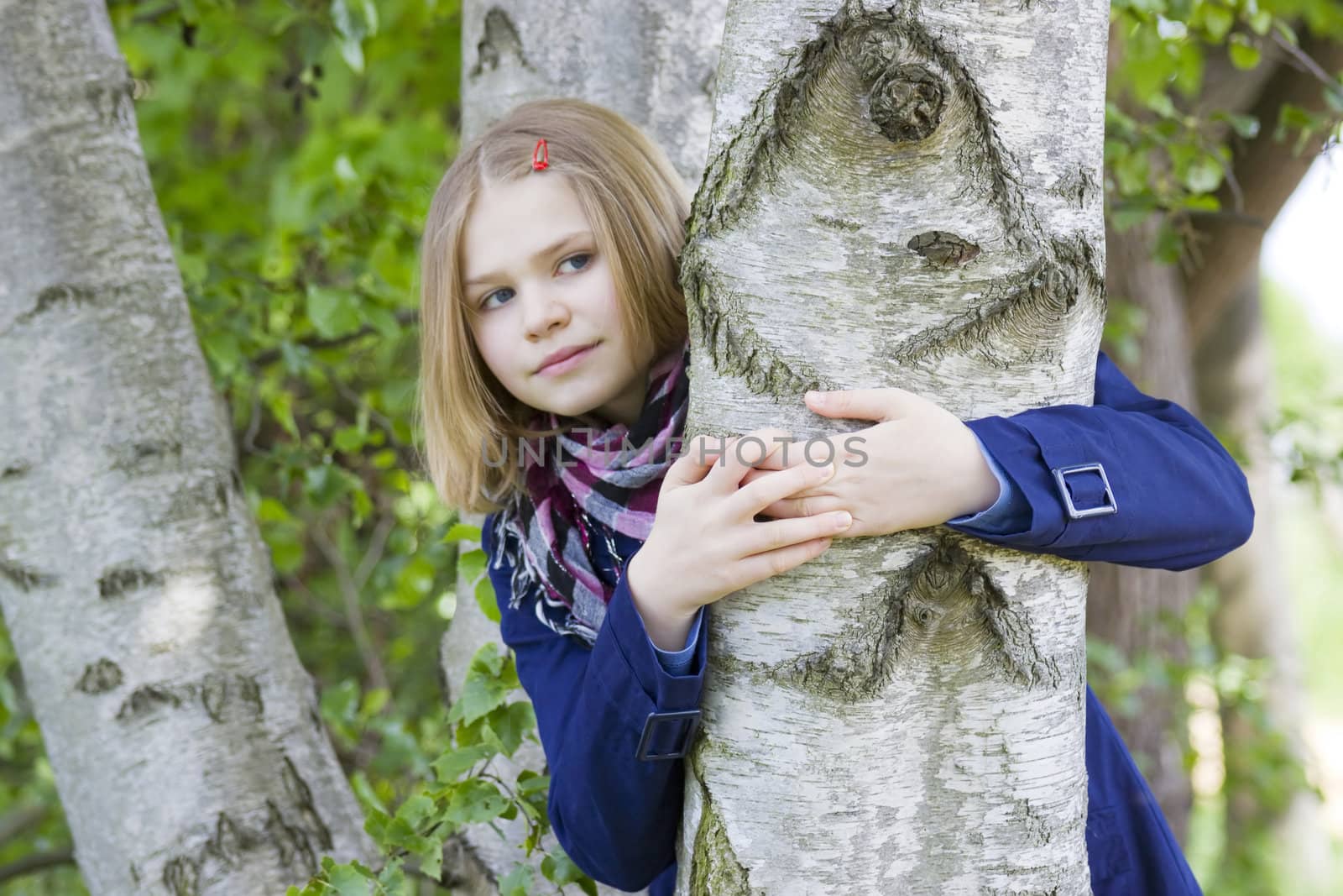 Girl hugging tree trunk and smiling  by miradrozdowski