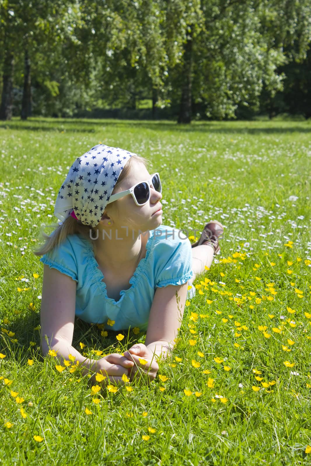 little girl lying on grass  by miradrozdowski