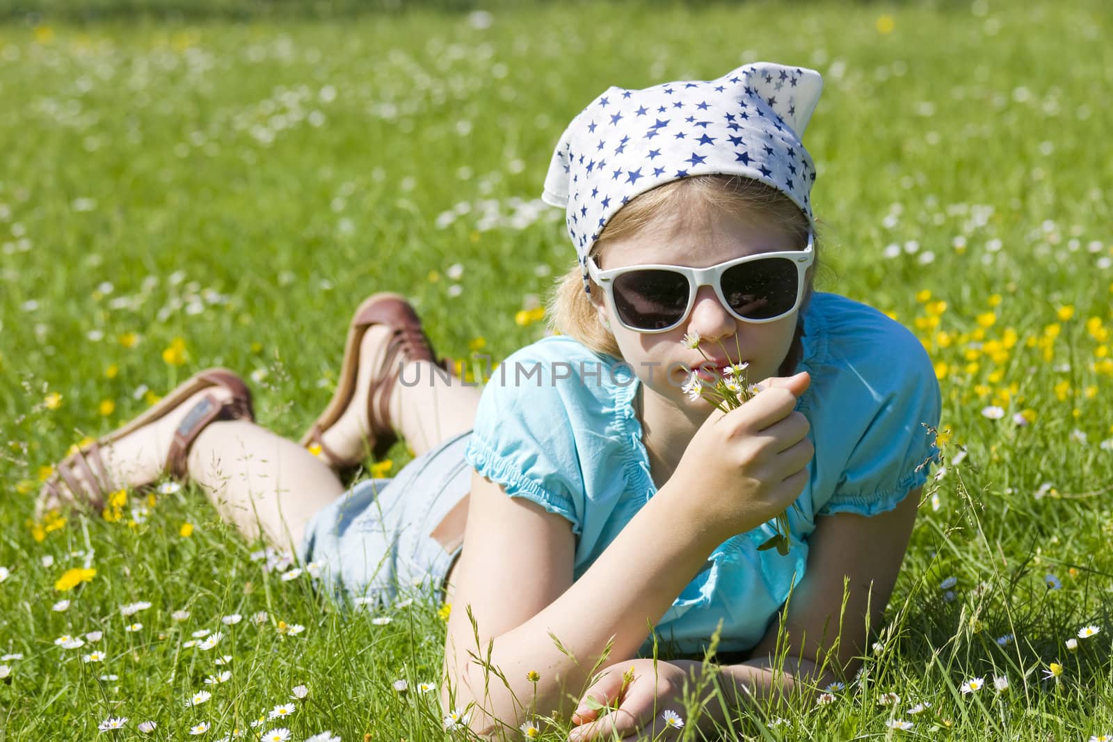 little girl lying on grass by miradrozdowski