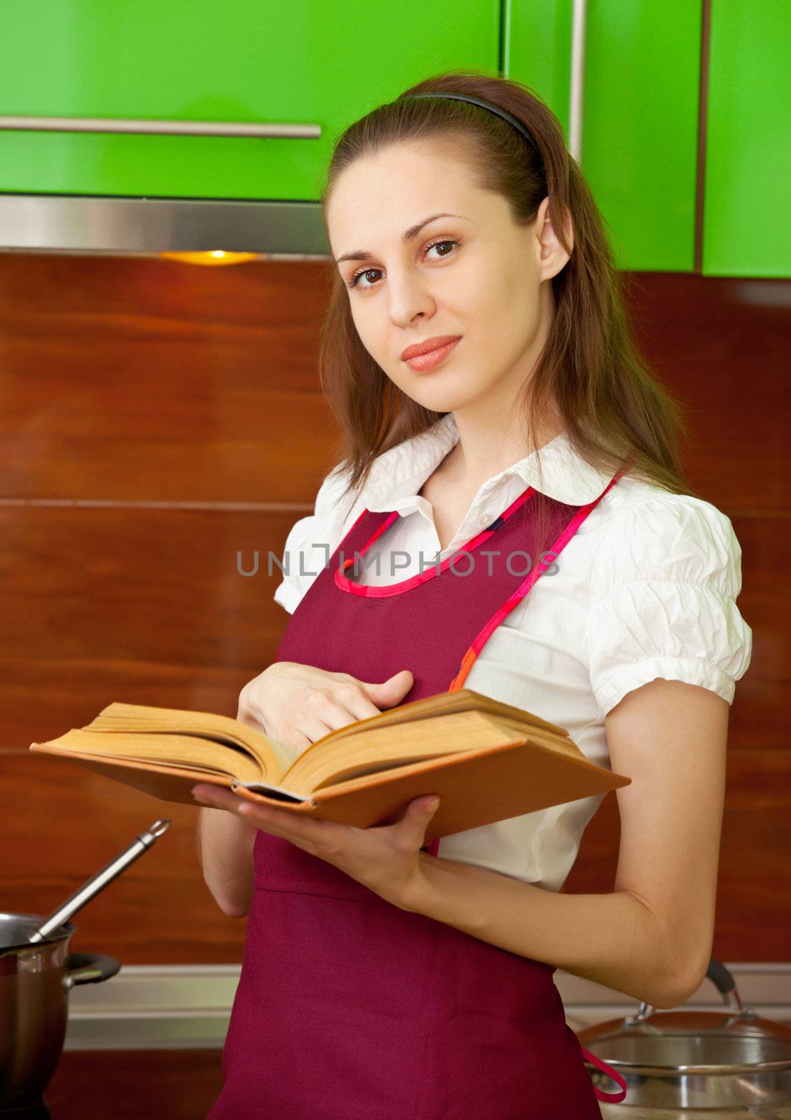 Woman reading a cookbook on kitchen by pzaxe