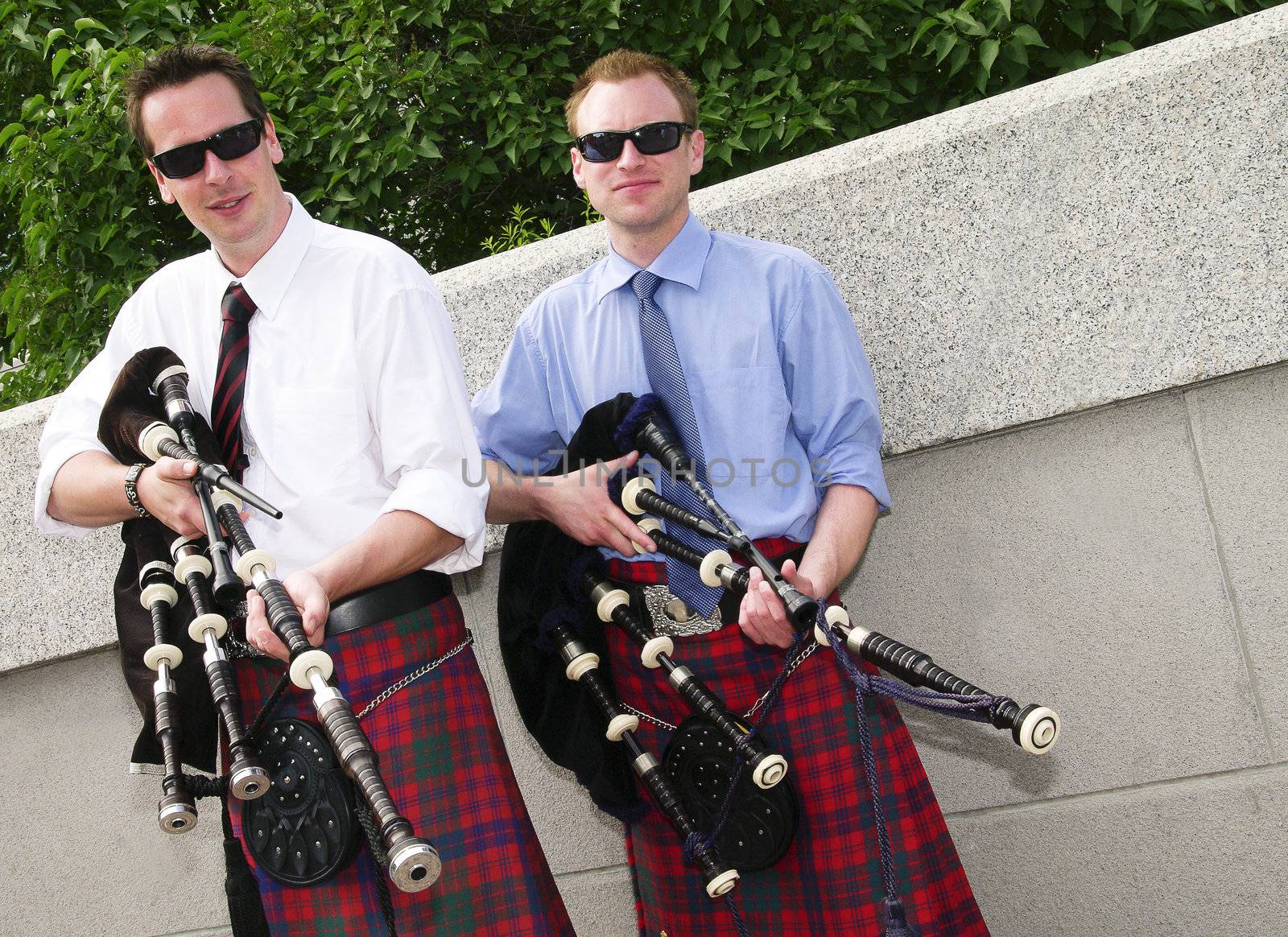 Bagpipe duo relaxing between songs as they entertain tourists in Ottawa, Canada.