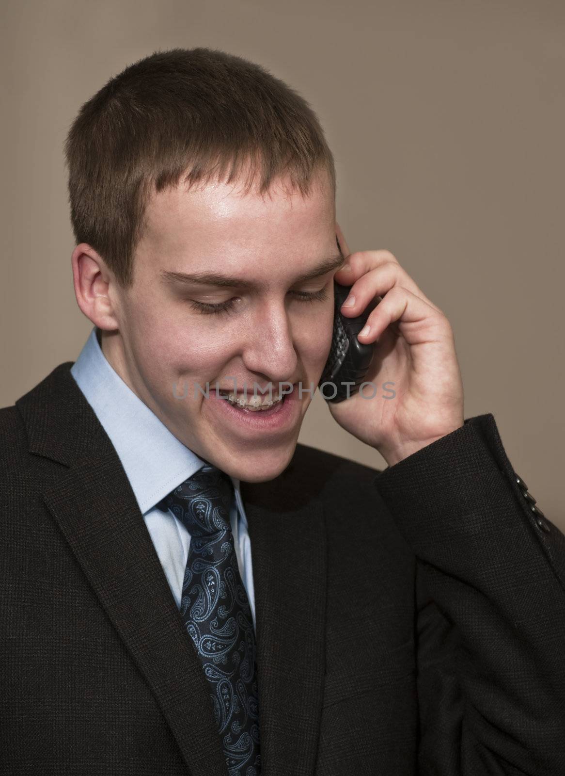 Young business man with braces speaking on cellphone.