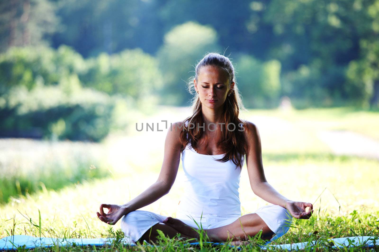 yoga woman on green grass in lotus pose
