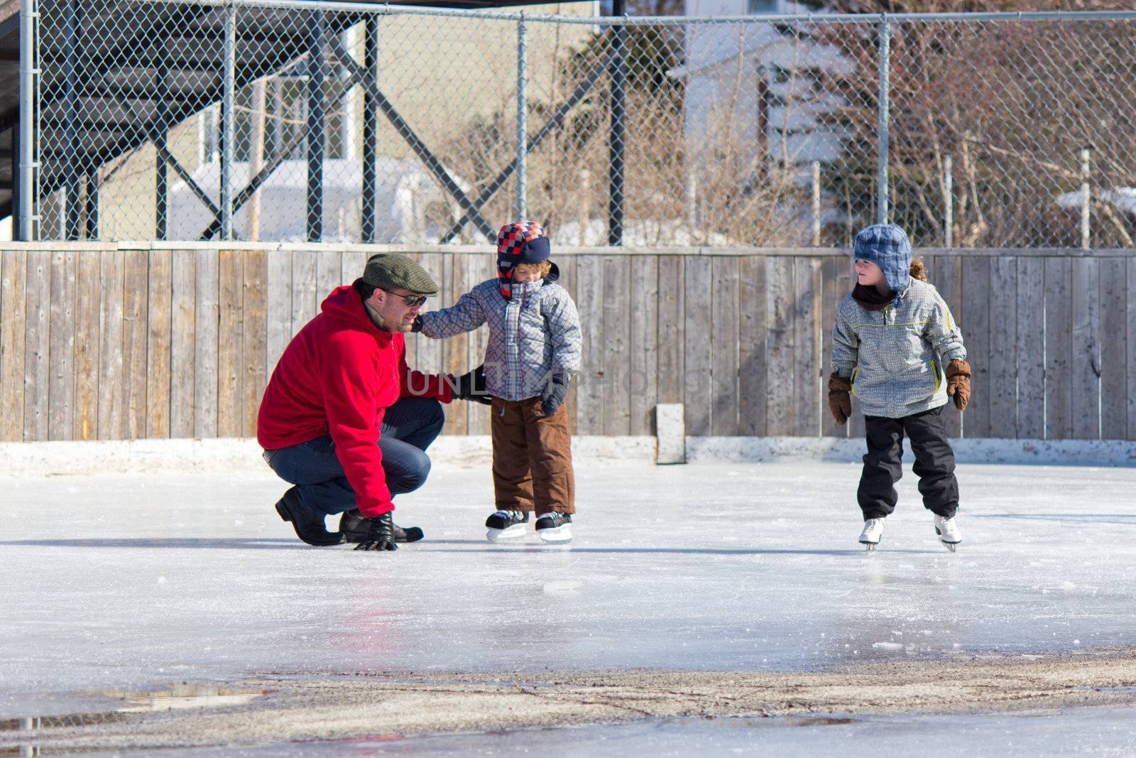 Family having fun at the outdoor skating rink in winter.