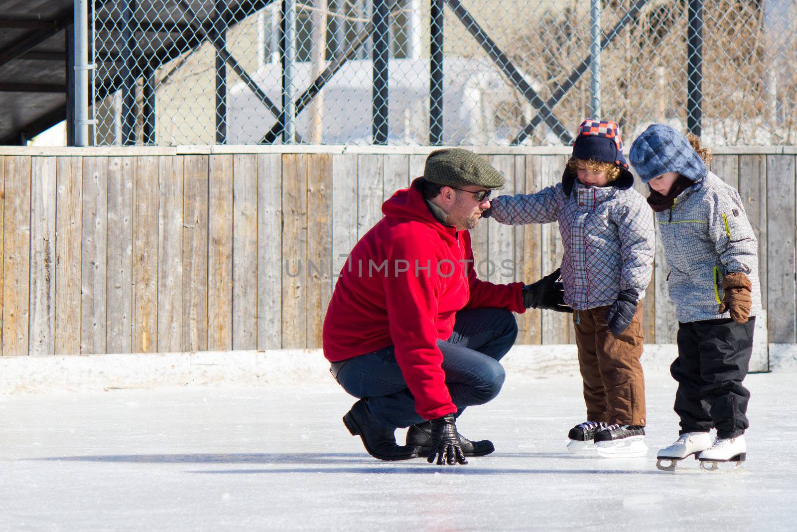 Family having fun at the outdoor skating rink in winter.