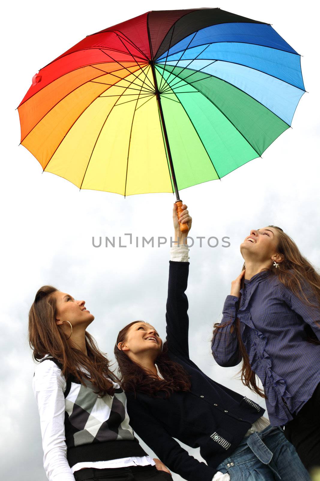 girlfriends stay under colourful umbrella 