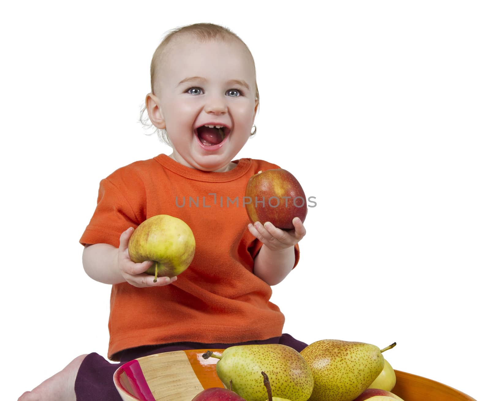 baby with apples and pears laying in bowl - studio shot