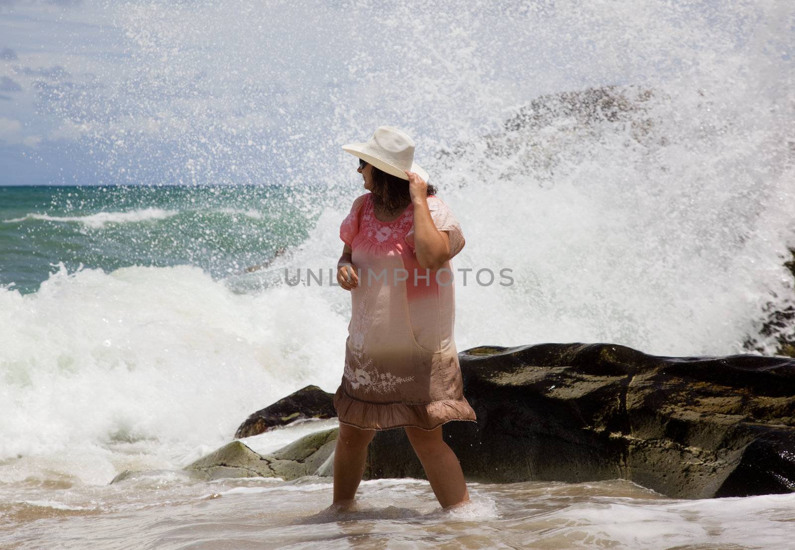 The lady in the white hat is the wave on the beach. Thailand.  Phuket