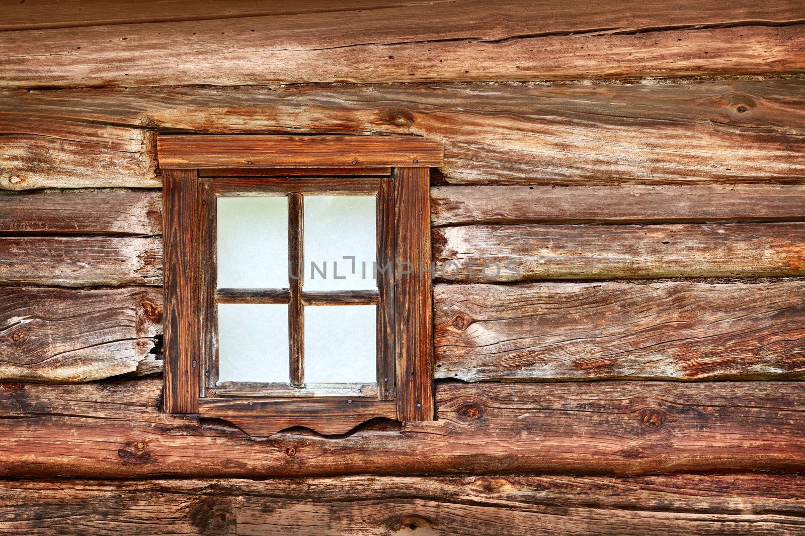 A small window in the wall of an old wooden house