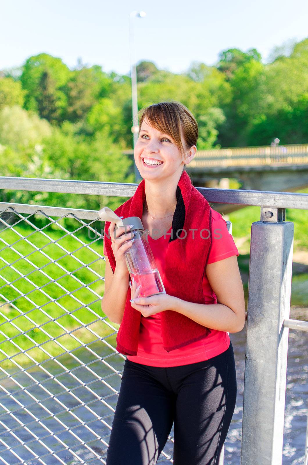 Smiling female runner with bottle of water