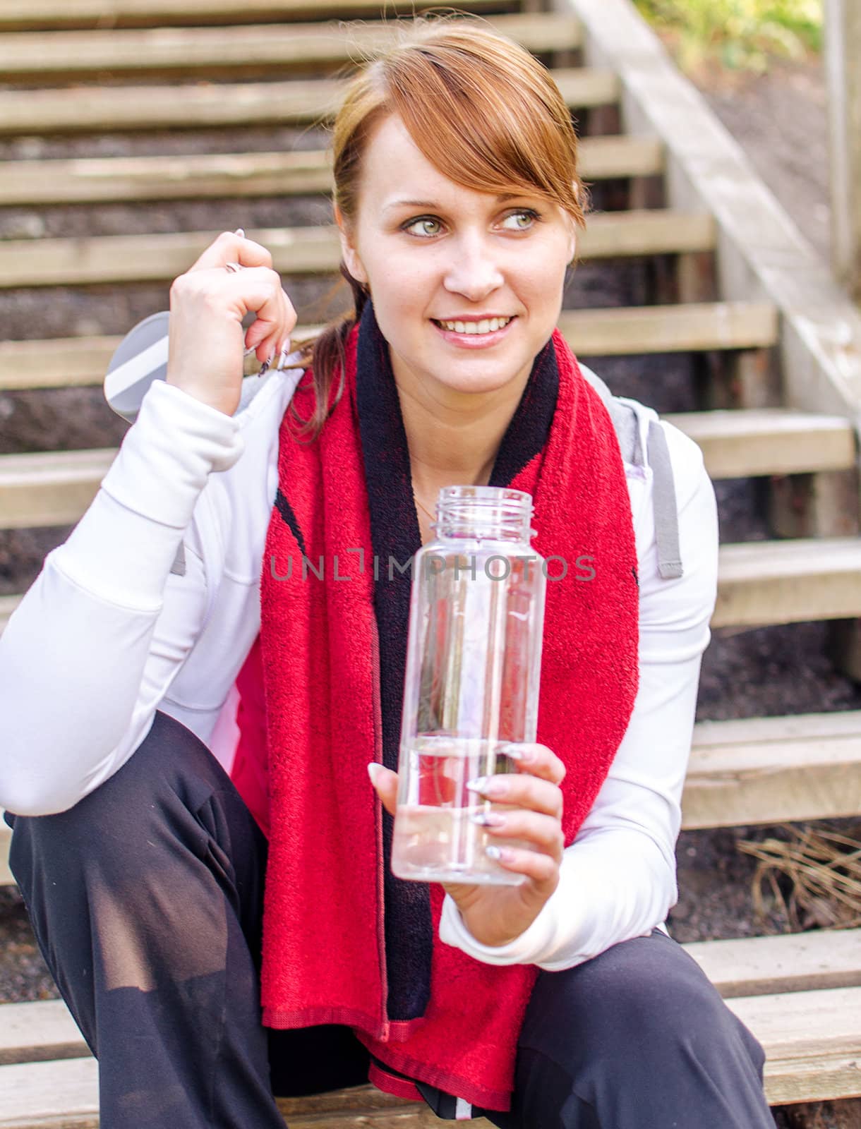 Smiling female runner with bottle of water