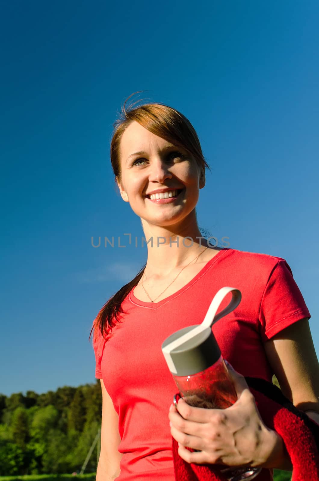 Smiling female runner with bottle of water