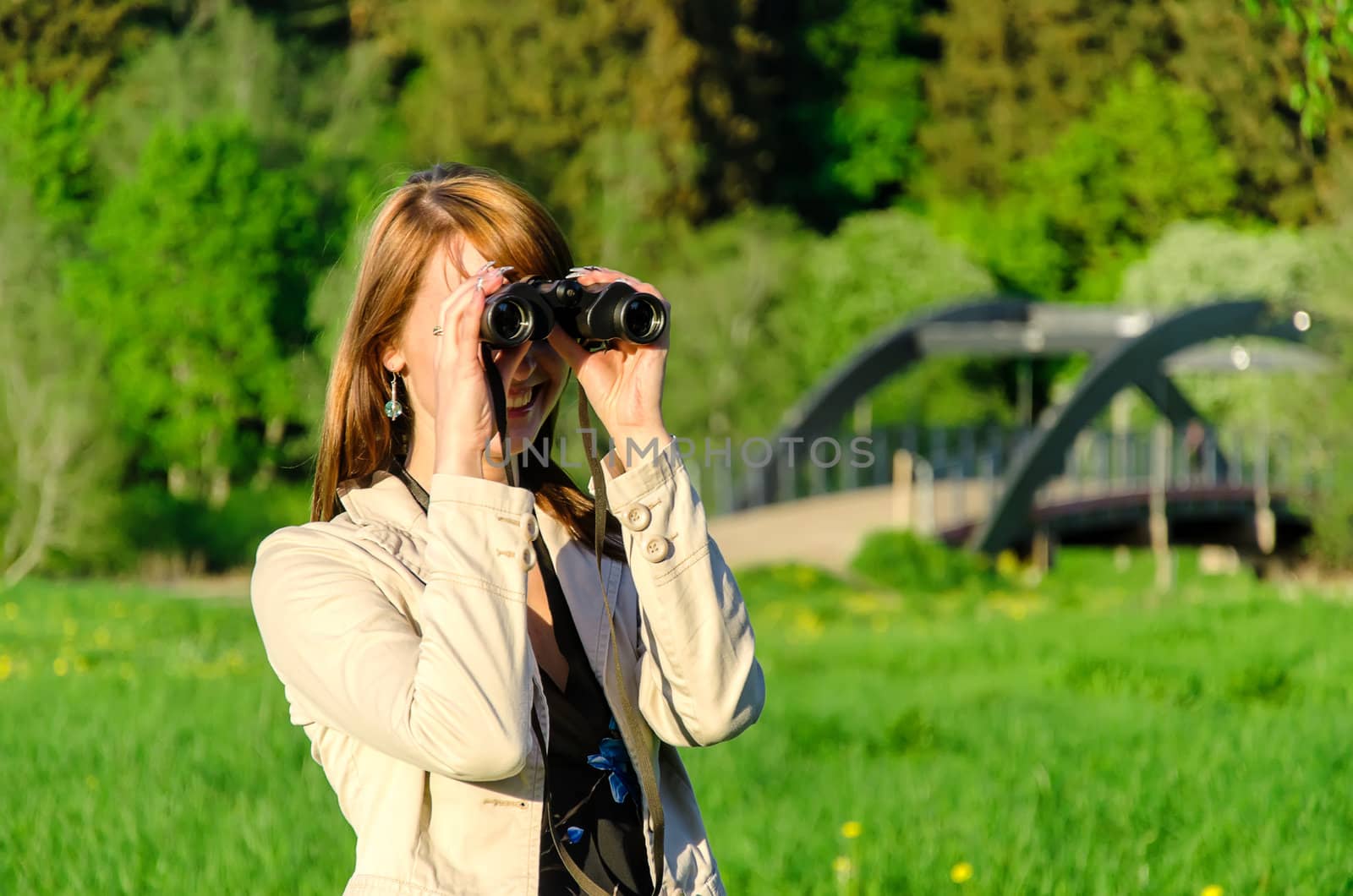 Attractive young woman looking through binoculars