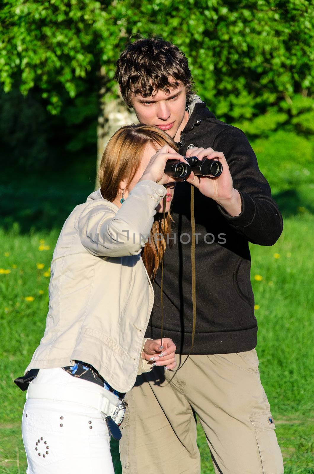 Attractive young woman looking through binoculars