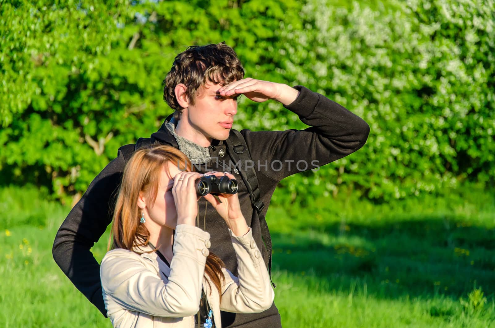 Attractive young woman looking through binoculars