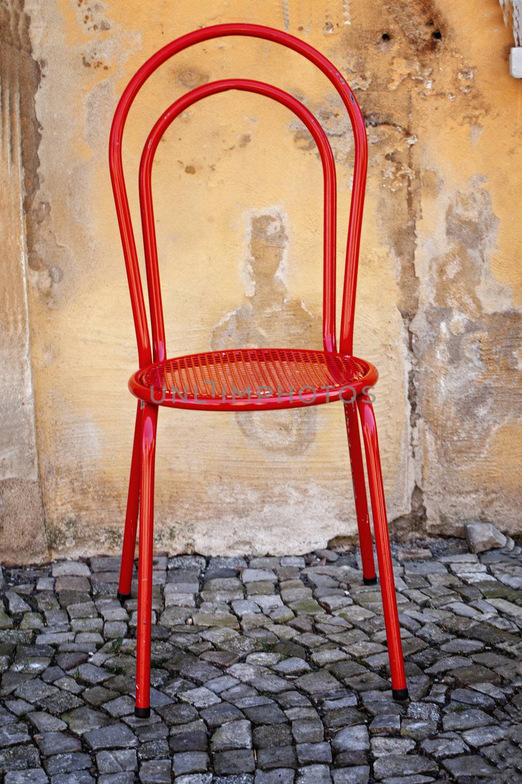 Old red Chair, on wall background by motorolka