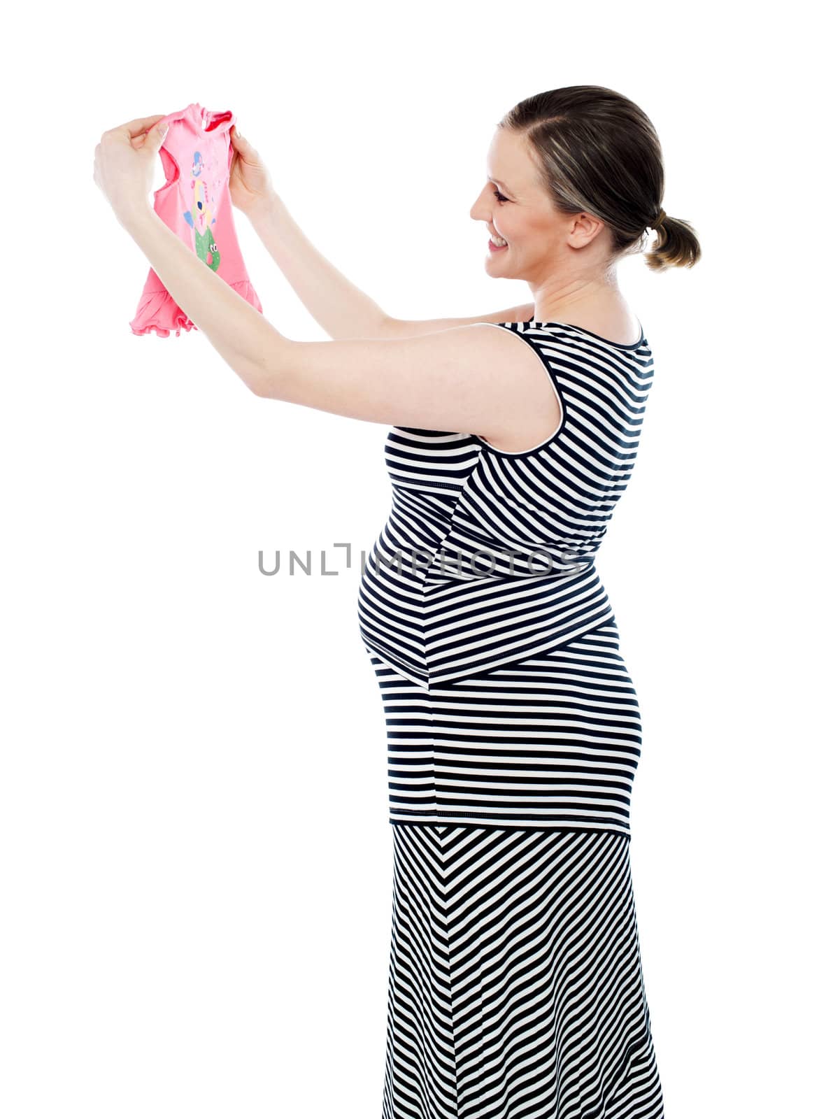 Pregnant woman holding and looking at baby cloth, rejoicing