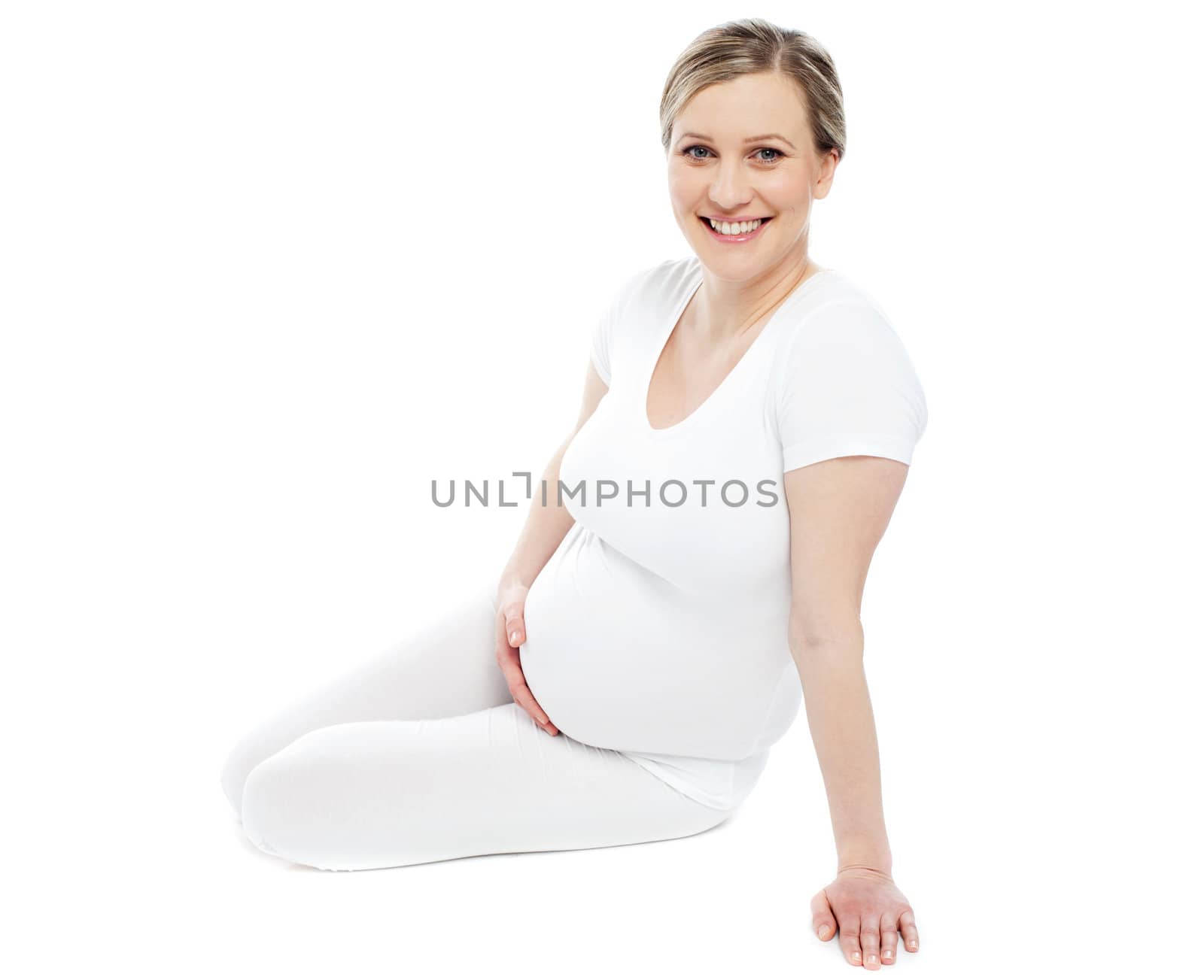 Studio portrait of pregnant woman dressed in white. Isolated