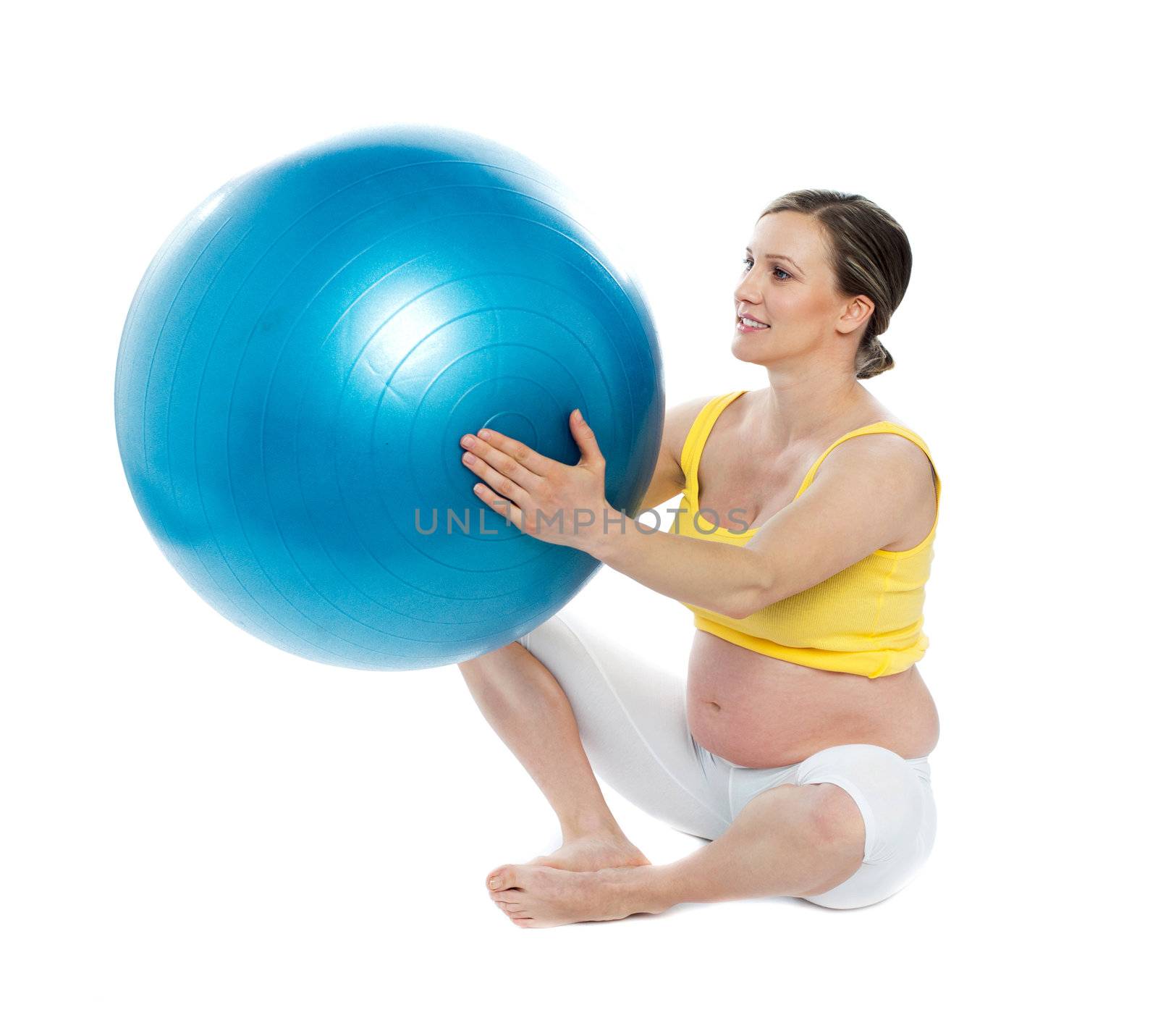 Pregnant woman excercises with a gymnastic ball by stockyimages