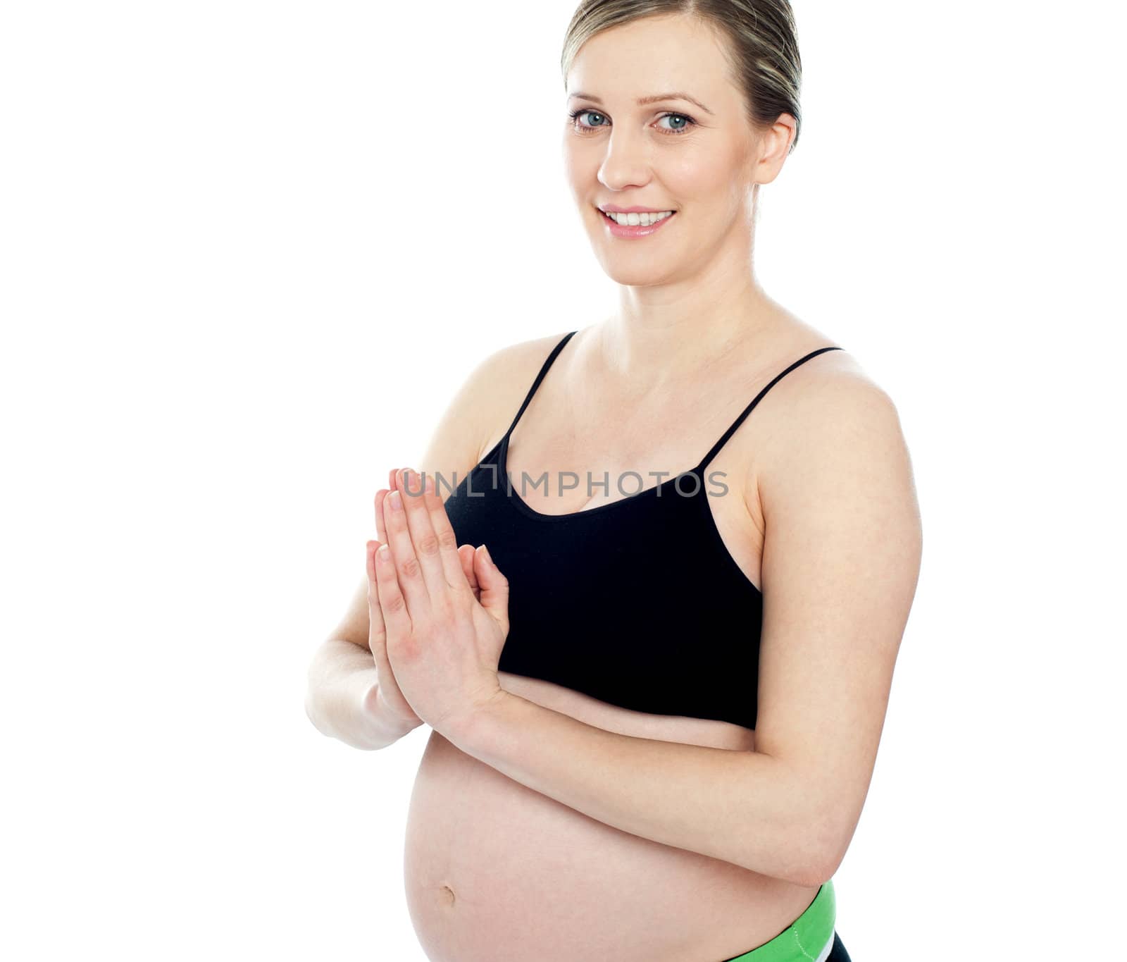 Gorgeous pregnant woman doing yoga. Welcome gesture.