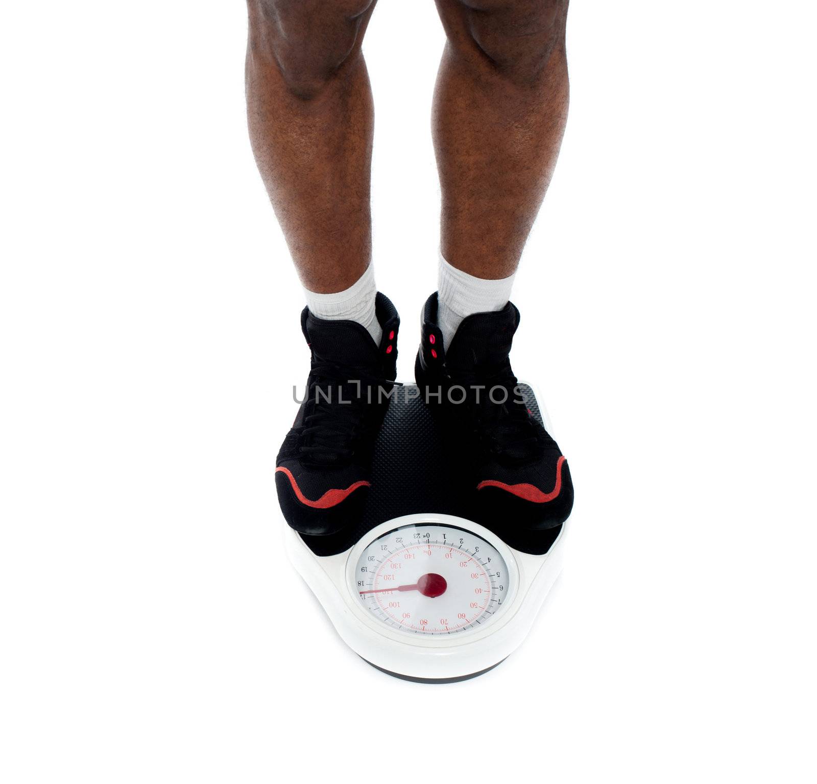 Man's feet on weighing scale isolated over white. Closeup