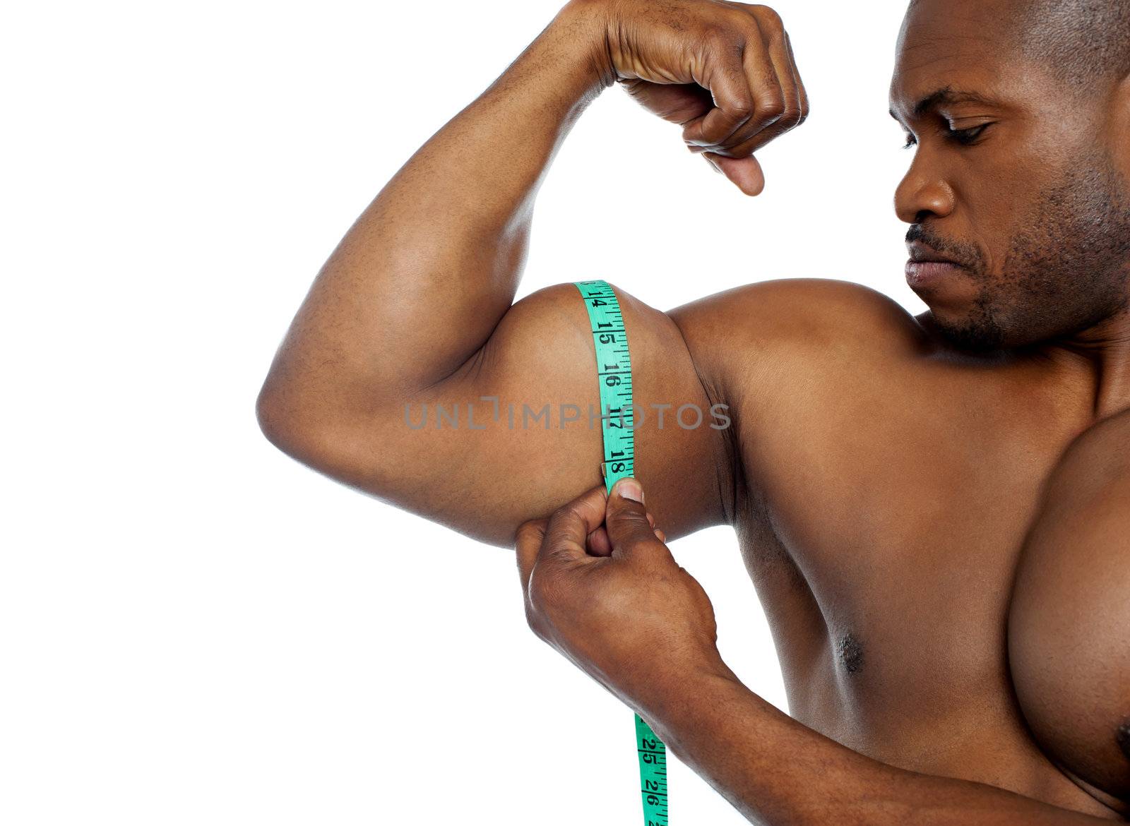Handsome guy measuring his biceps with tape, closeup