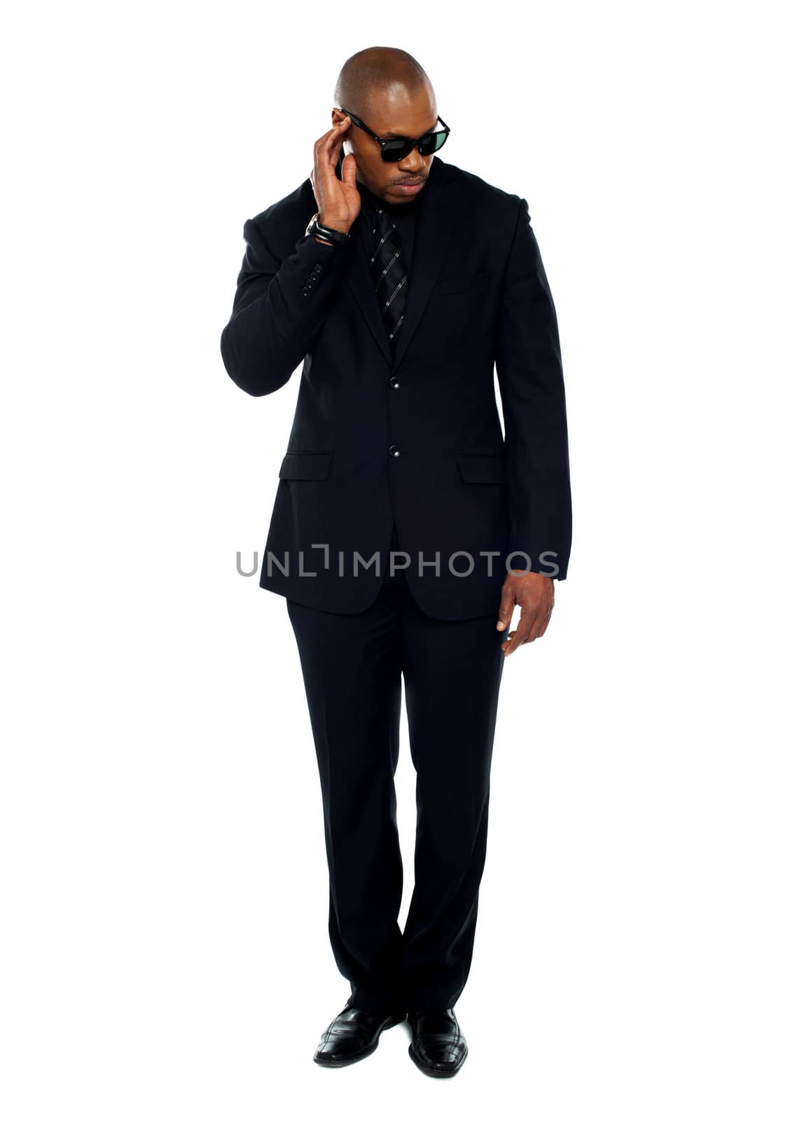 African businessman trying to listen to something isolated over white background