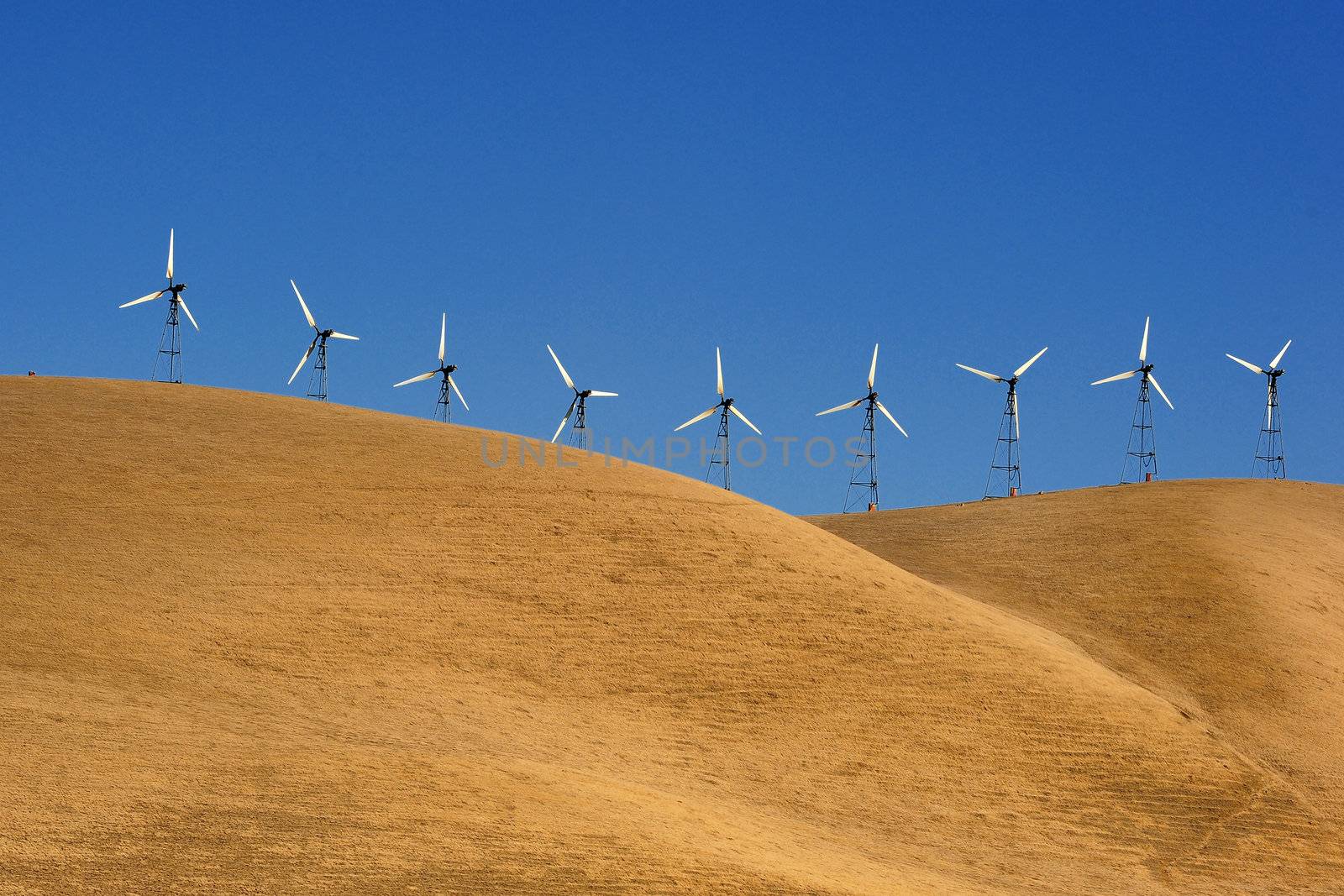 clean energy or wind power generator on golden grass hill in california