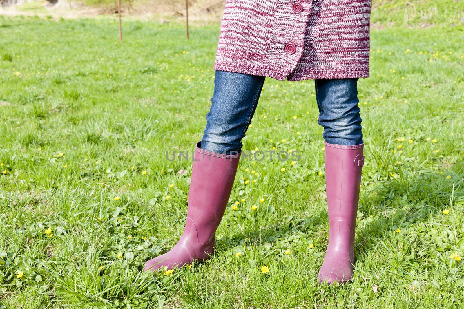 detail of woman wearing rubber boots on spring meadow by phbcz