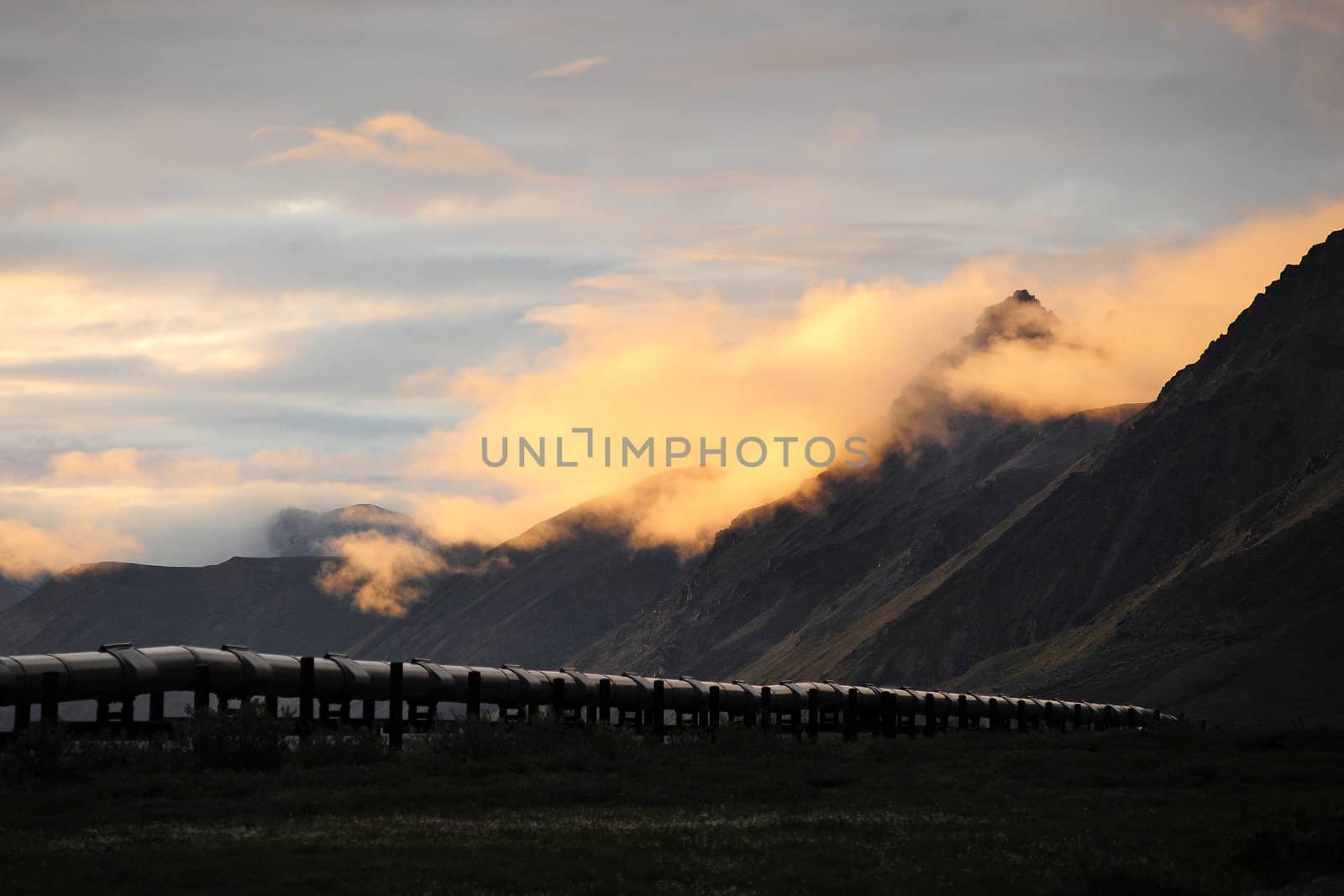 trans-Alaska oil pipeline at Brooks mountain range, Northern Alaska with midnight sunlight