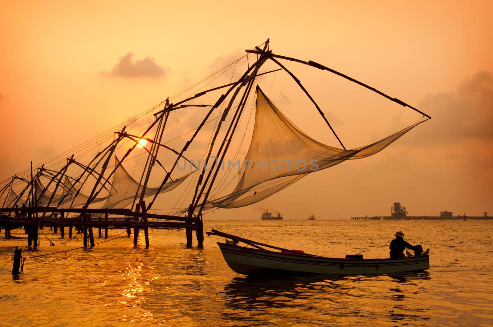 Sunset over Chinese Fishing nets and boat in Cochin (Kochi), Kerala, India.