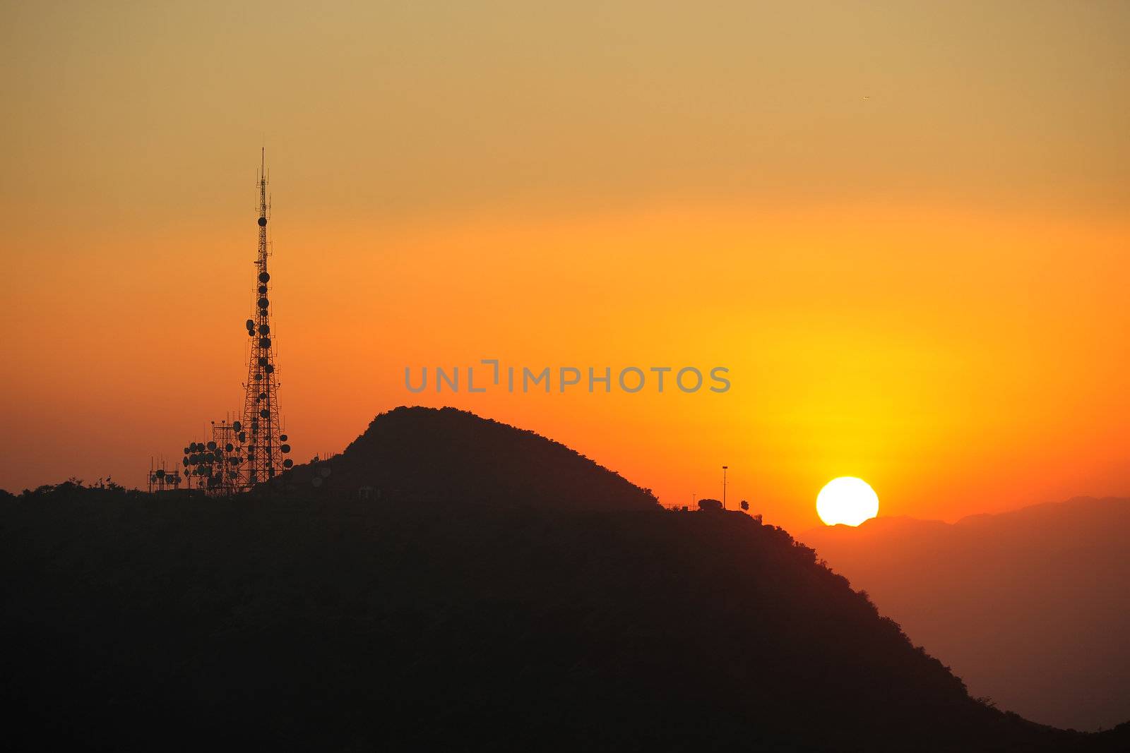 sunset over mountains with radio station