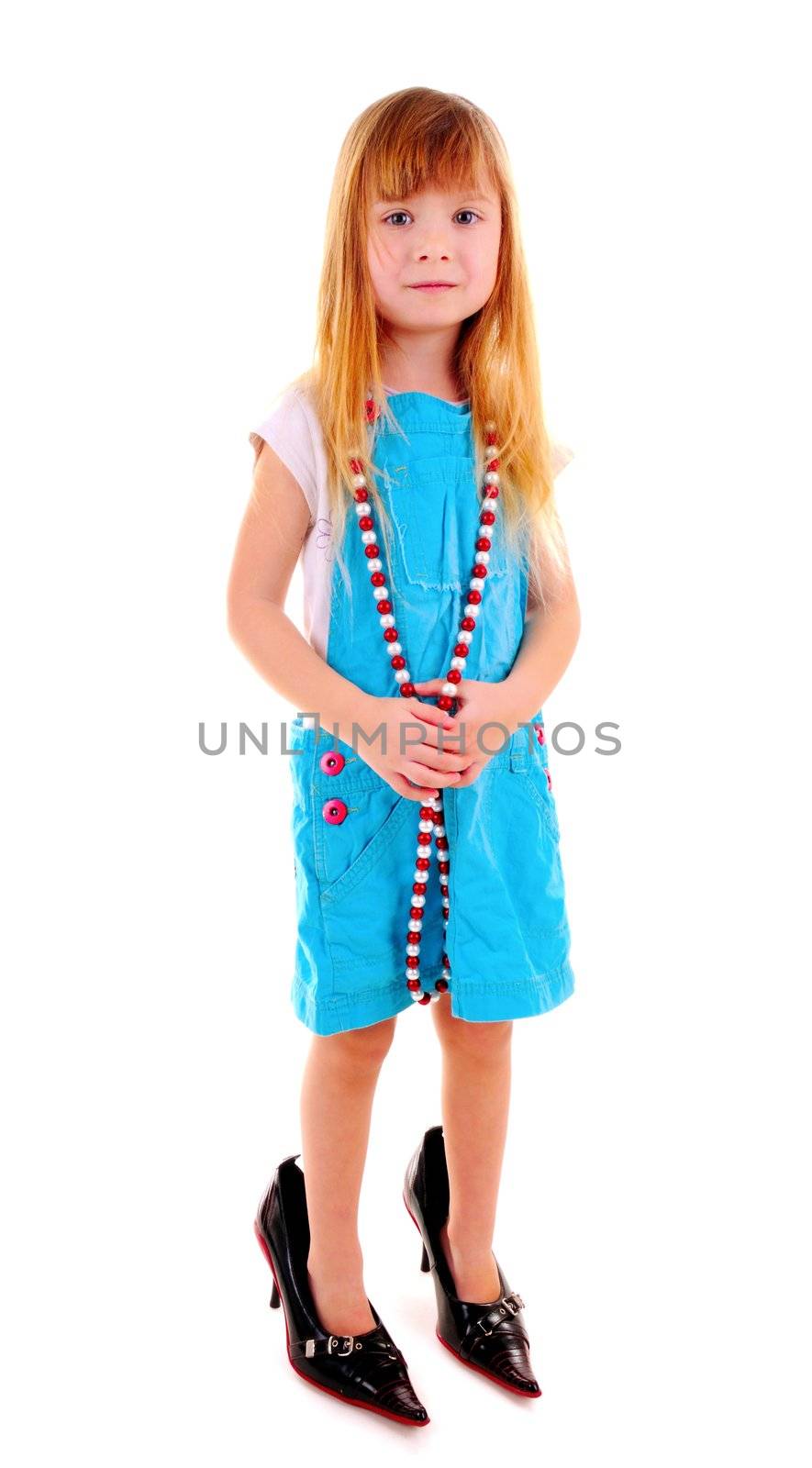 Small blonde girl in mam's high-heeled shoes on white background