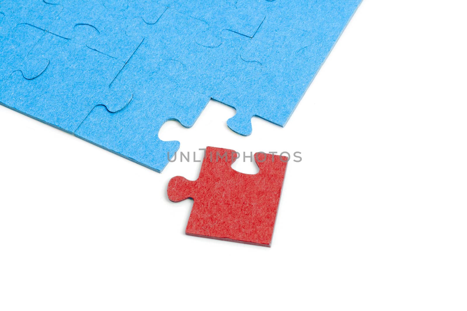 Blue Puzzle with one red jigsaw piece isolated on white background