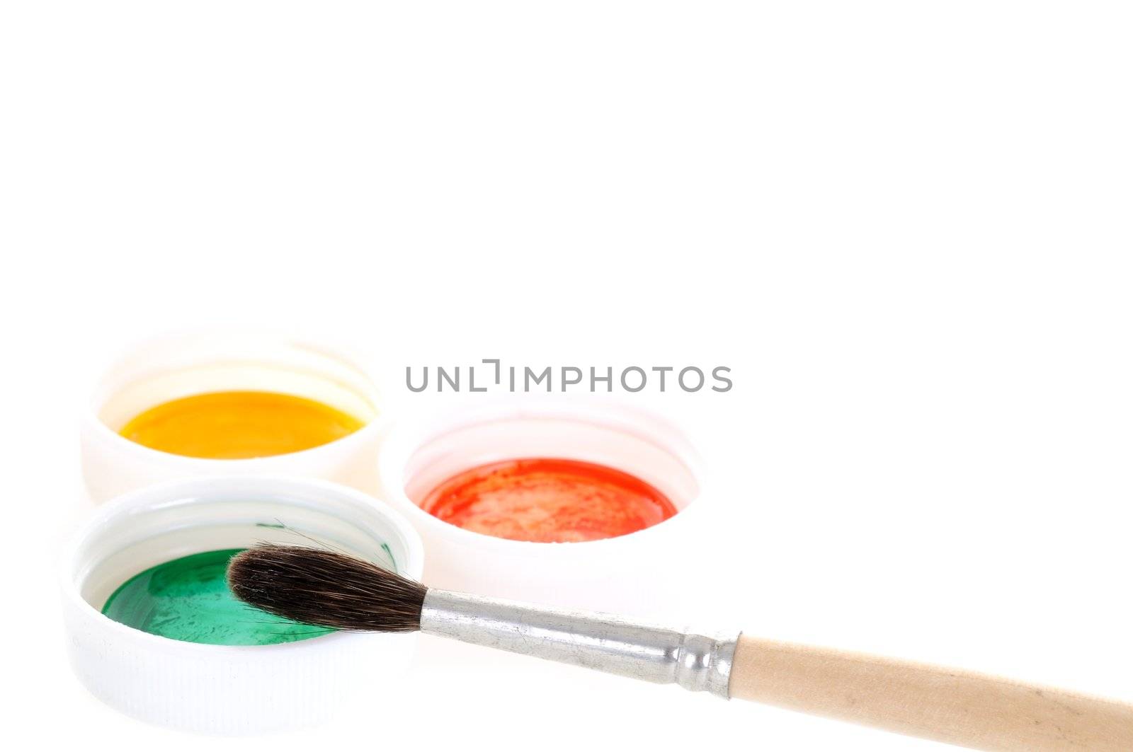 Small brush with three paint covers on white background
