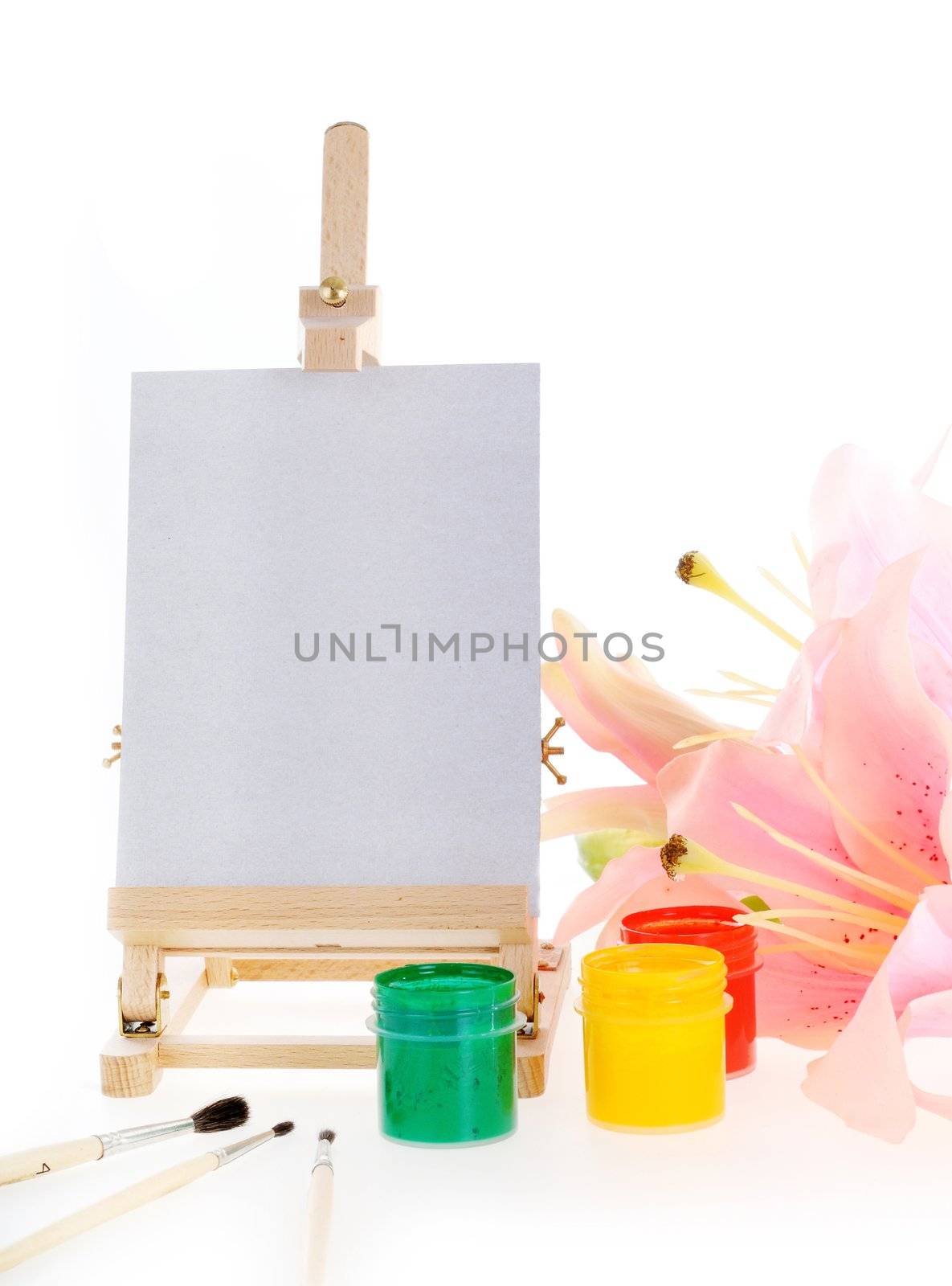 Three paints, brushes, easel and beauty flower