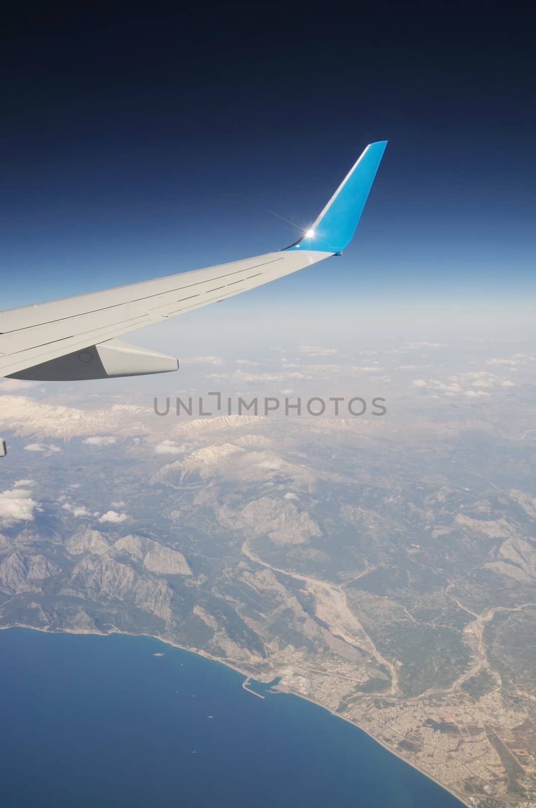 Airplane's wing undermountains and sea