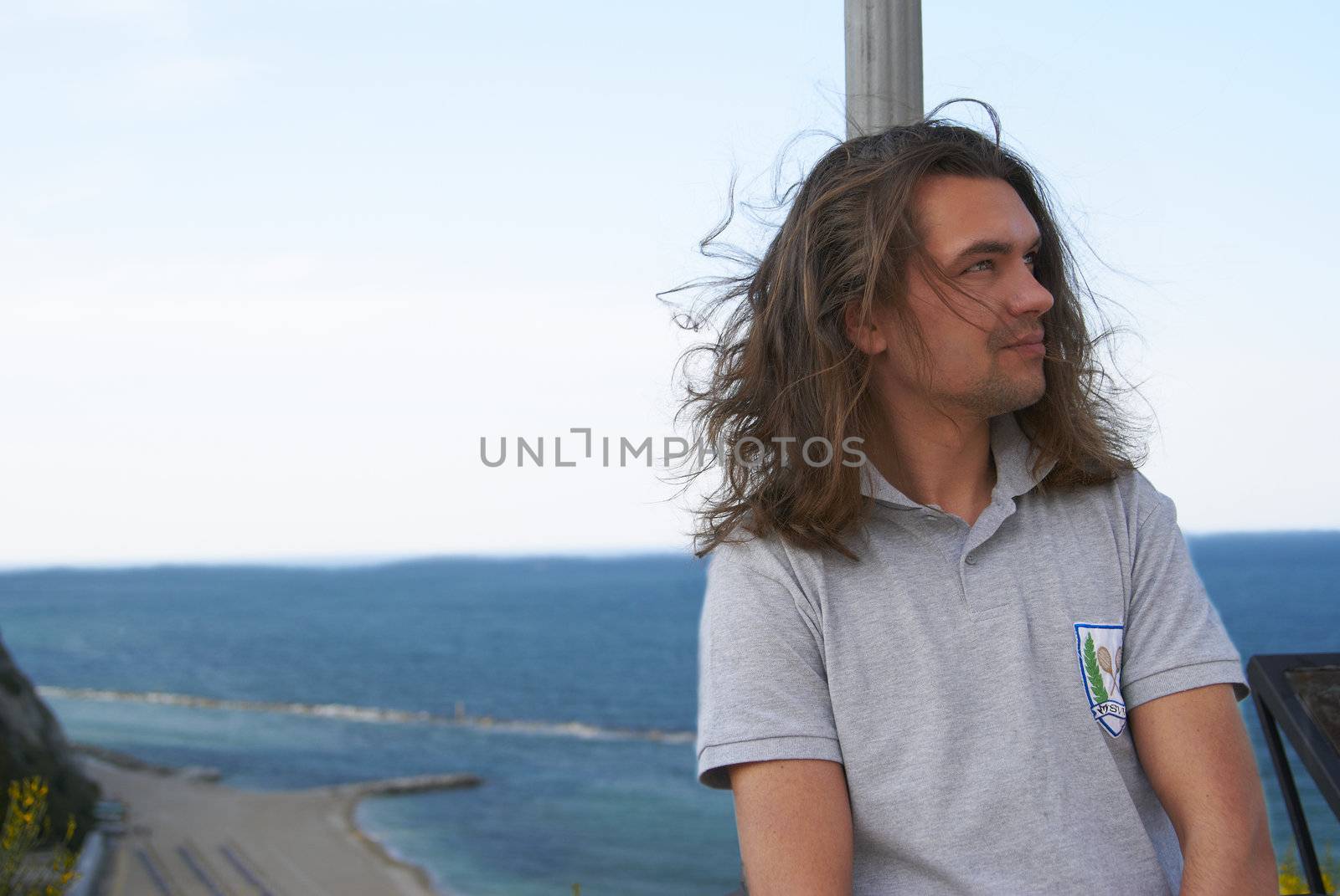 Portrait of a young handsome guy on the background of the summer seascape
