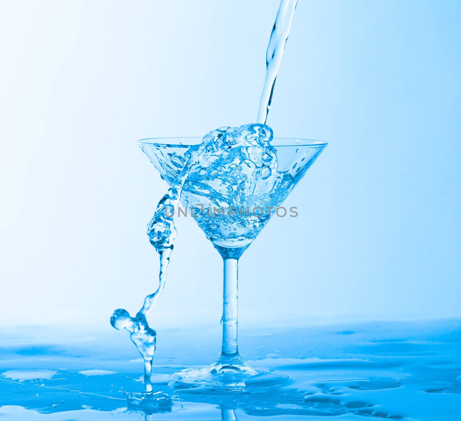 Water Splashing in a Wineglass, on blue background