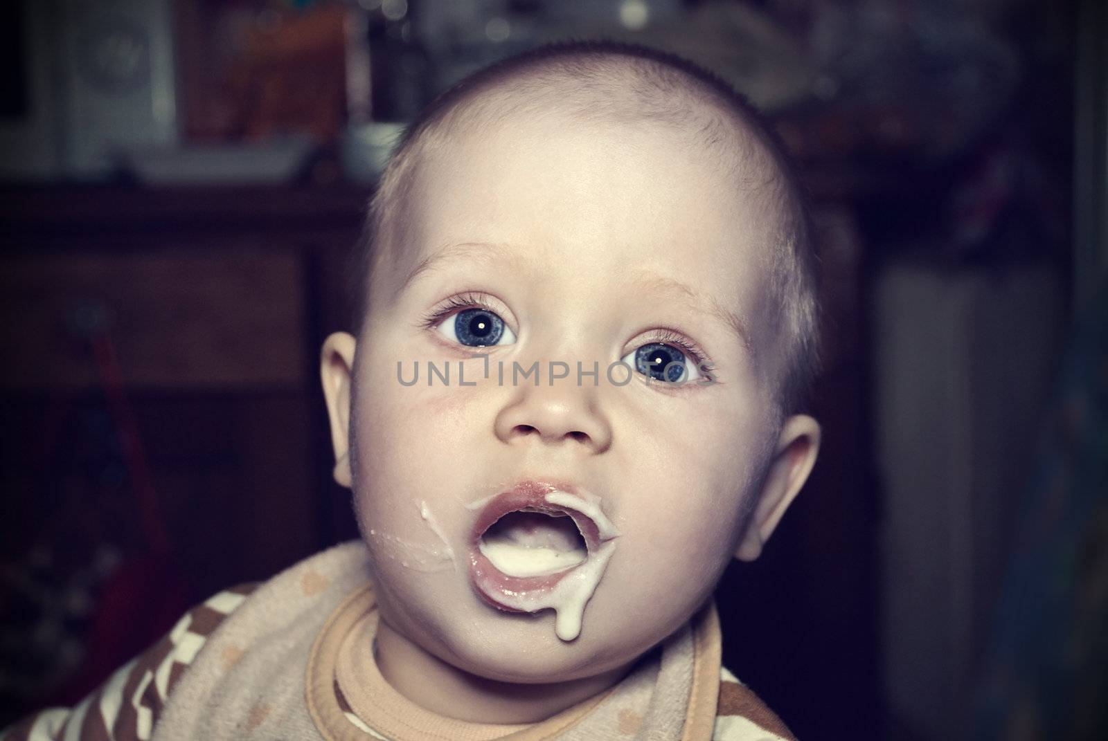Portrait of a cute little baby eat porridge.