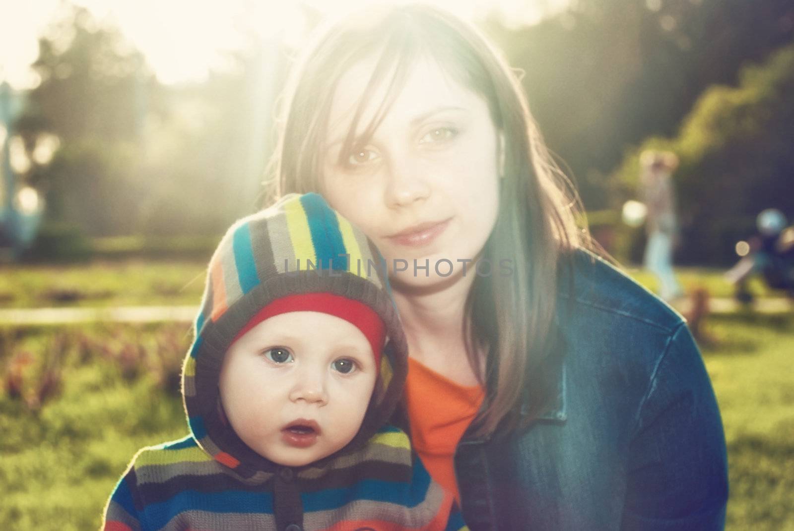 Little boy with his mother in a sunny park. Defocused images