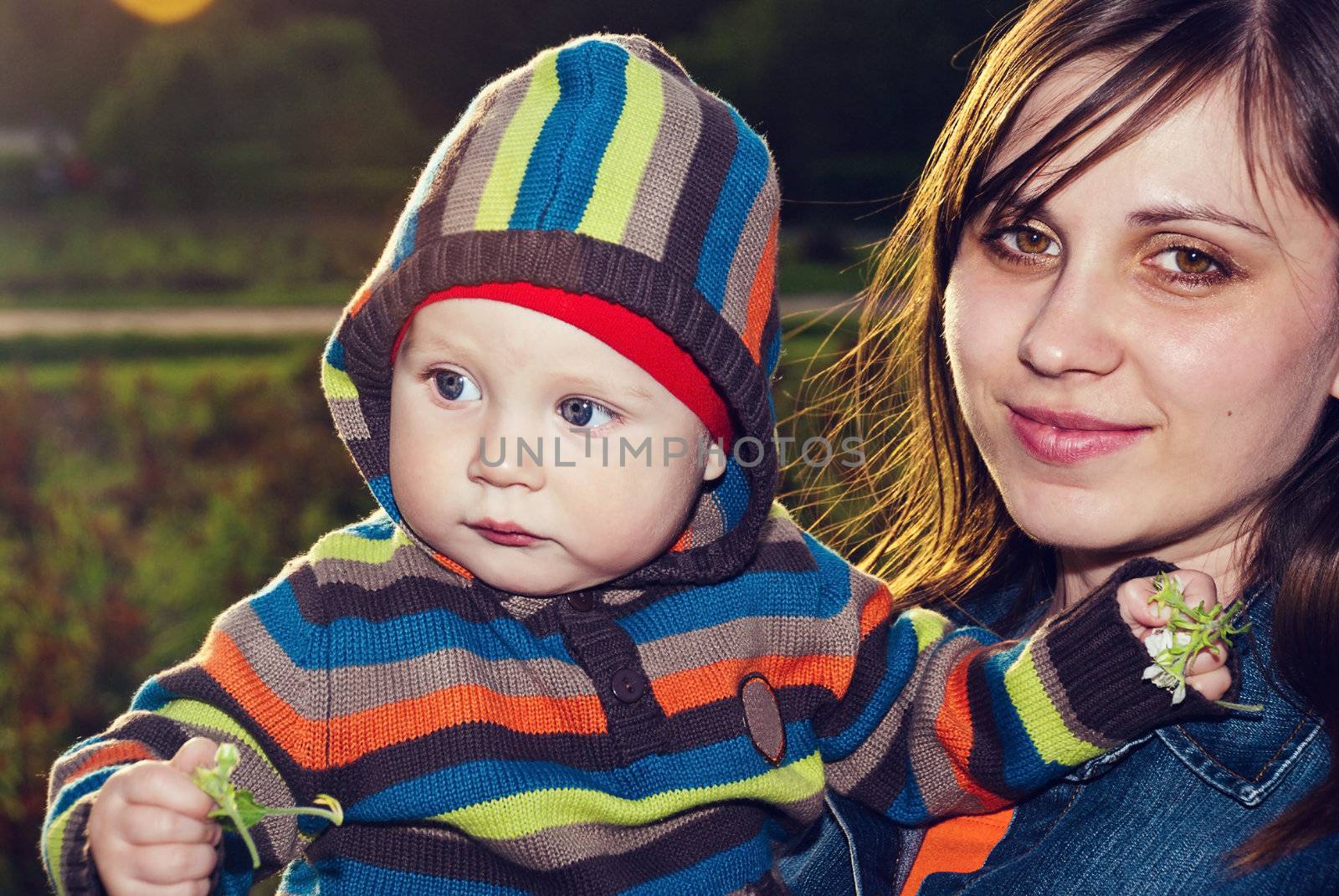 Happy mother with her son in her arms in the park.