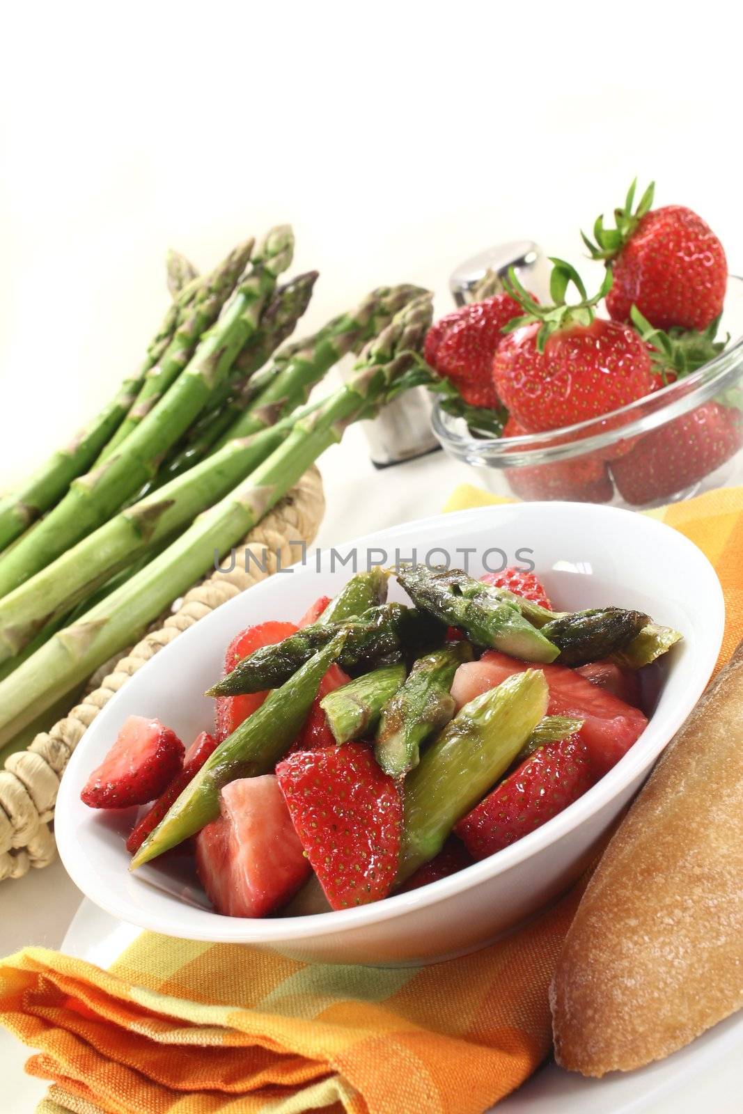 a bowl of asparagus strawberry salad with roasted green asparagus