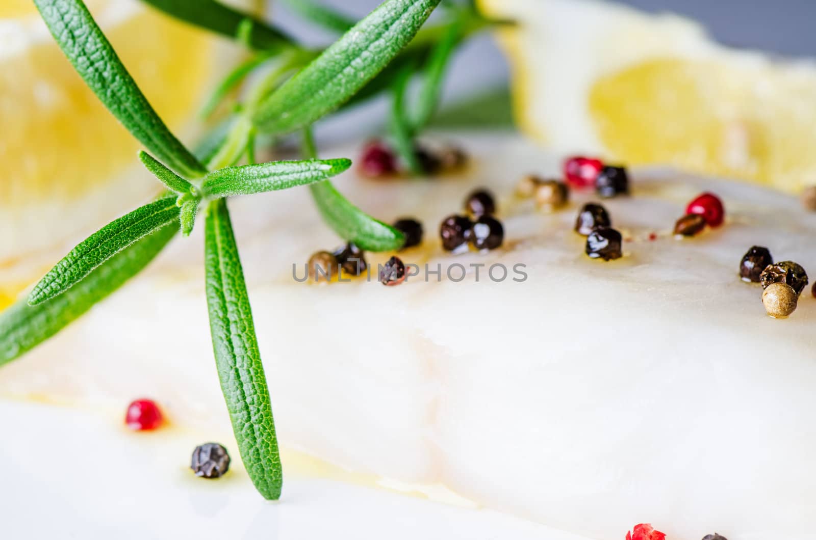 Raw fish with herbs and lemon close up by Nanisimova