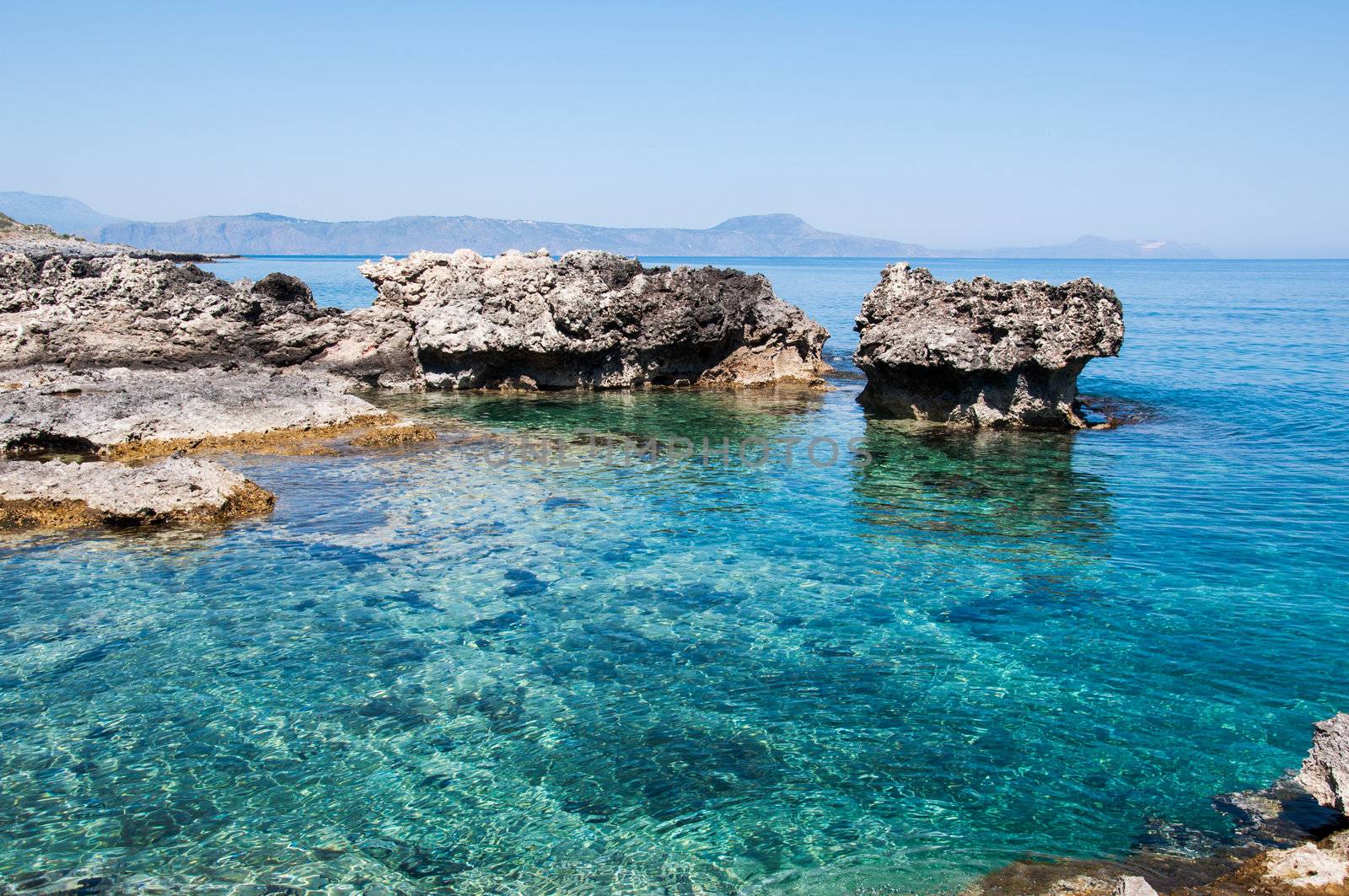 Big rocks and shallow emerald sea at Crete Island Greece.