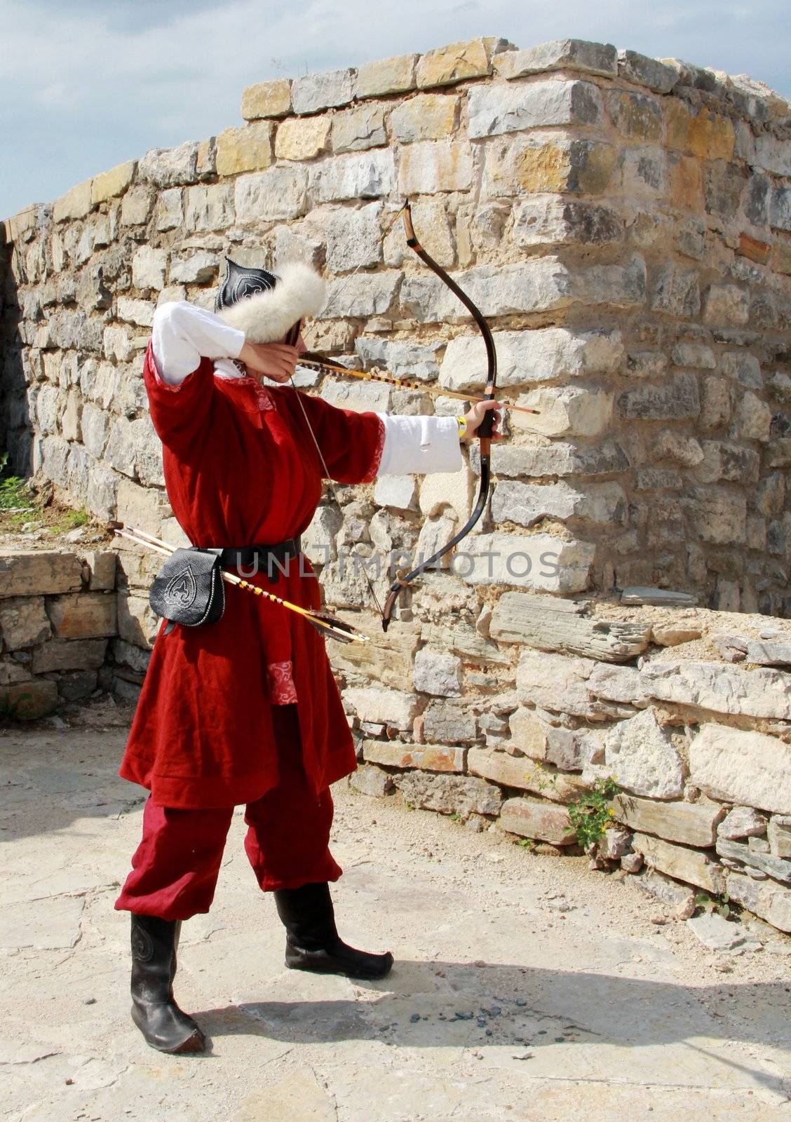 Beautiful young girl with bow and arrows in medieval costume