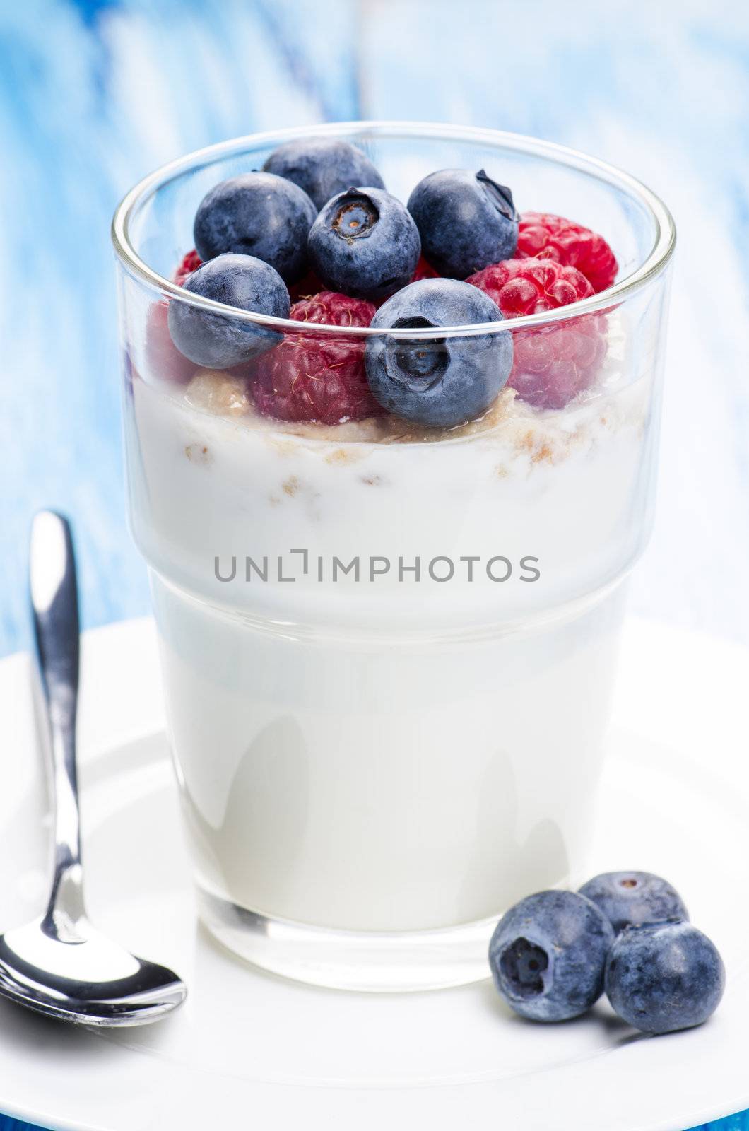 Yogurt with raspberries and blueberries in a glass
