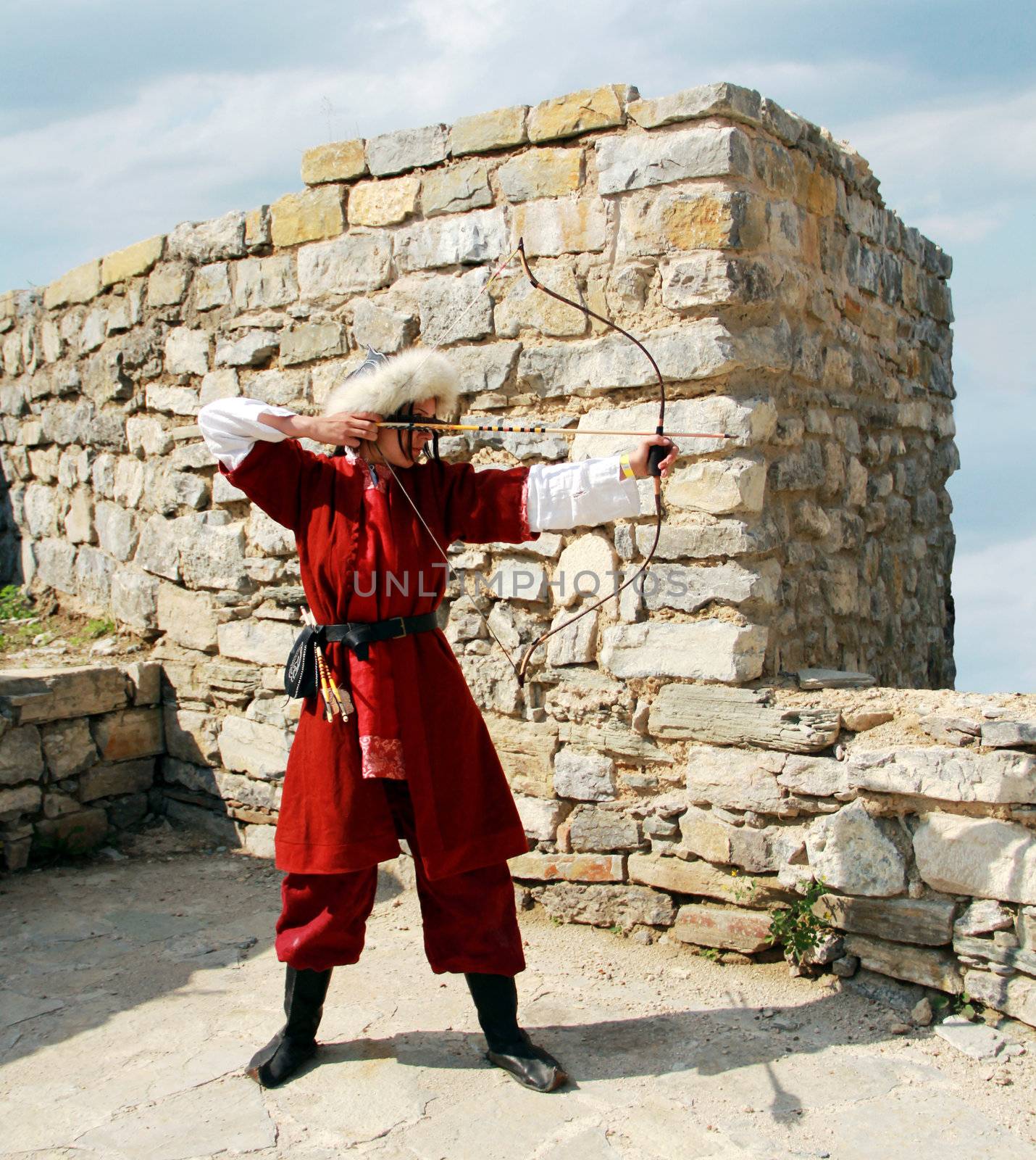 Beautiful young girl with bow and arrows in medieval costume